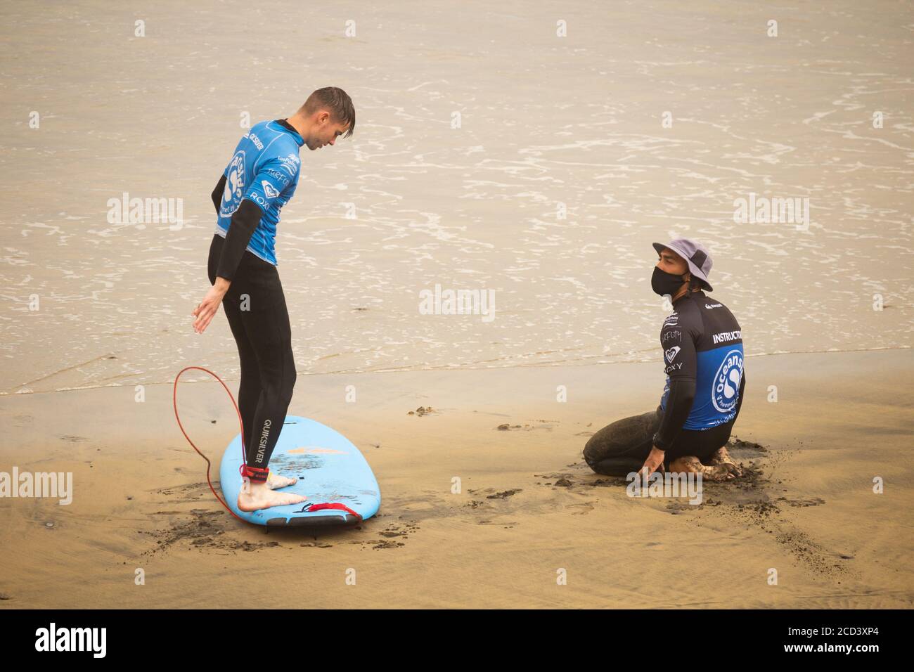 Las Palmas, Gran Canaria, Kanarische Inseln, Spanien. August 2020. Surflehrer mit Gesichtsmaske am Stadtstrand in Las Palmas auf Gran Canaria. Mit Covid 19 Fällen steigt auf Gran Canaria, hat die lokale Regierung verboten Joggen auf der Strandpromenade während des Tages sowie Sonnenbaden am Strand bei Flut zu verhindern, dass Gedränge. Im August wurden auf Gran Canaria mehr neue Coronavirus-Fälle registriert als in den Monaten März bis August zusammen. Mehr als 100 der neuen Fälle wurden auf eine Disco in der Hauptstadt Las Palmas zurückgeführt. Kredit: Alan Dawson/Ala Stockfoto