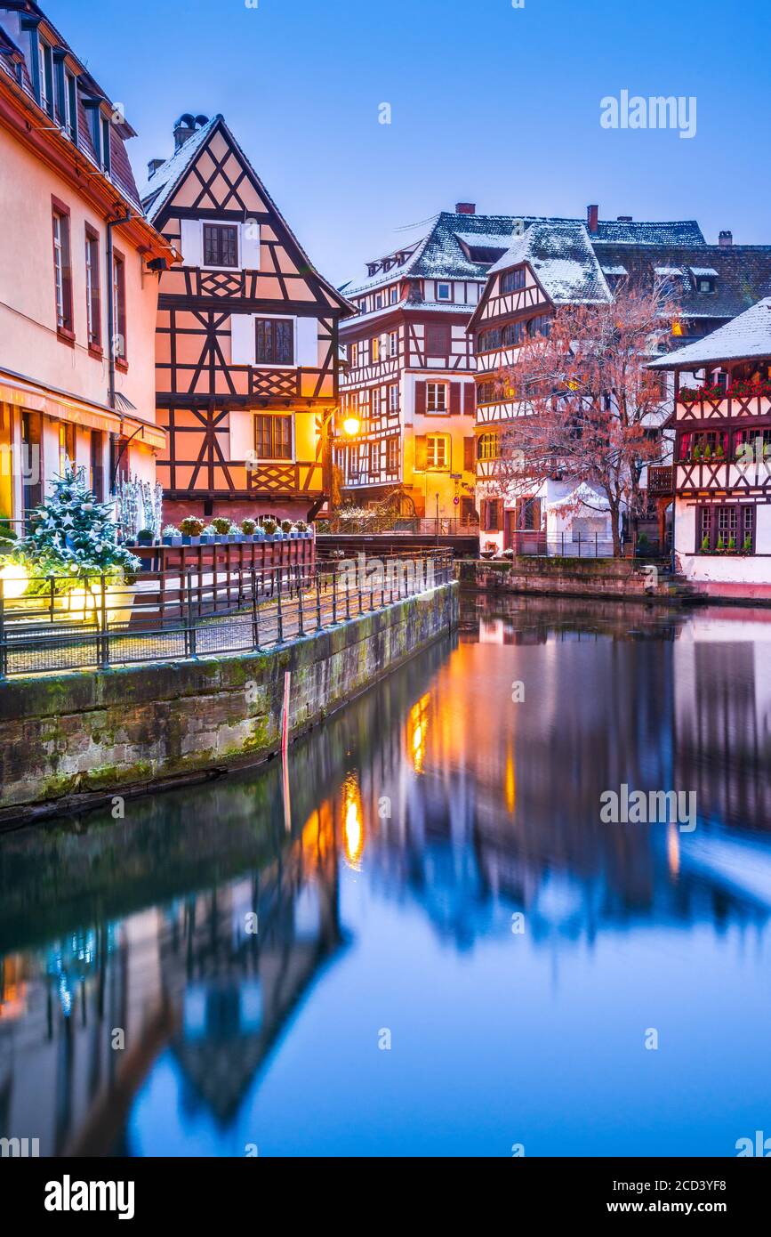 Straßburg, Elsass, Frankreich. Traditionelle elsässische Fachwerkhäuser mit Spiegelreflexen in Petite France während der Dämmerung zu Weihnachten dekoriert Stockfoto