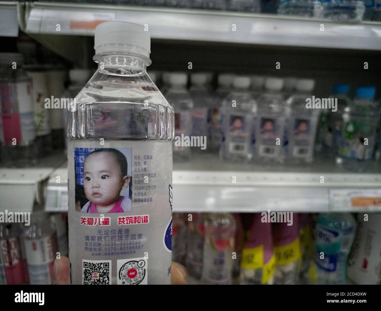 Arrays von Flaschen Sodawasser, auf deren Oberfläche Informationen über vermisste Kinder angezeigt werden, die dazu beitragen, diese Kinder für ihre p zu finden Stockfoto