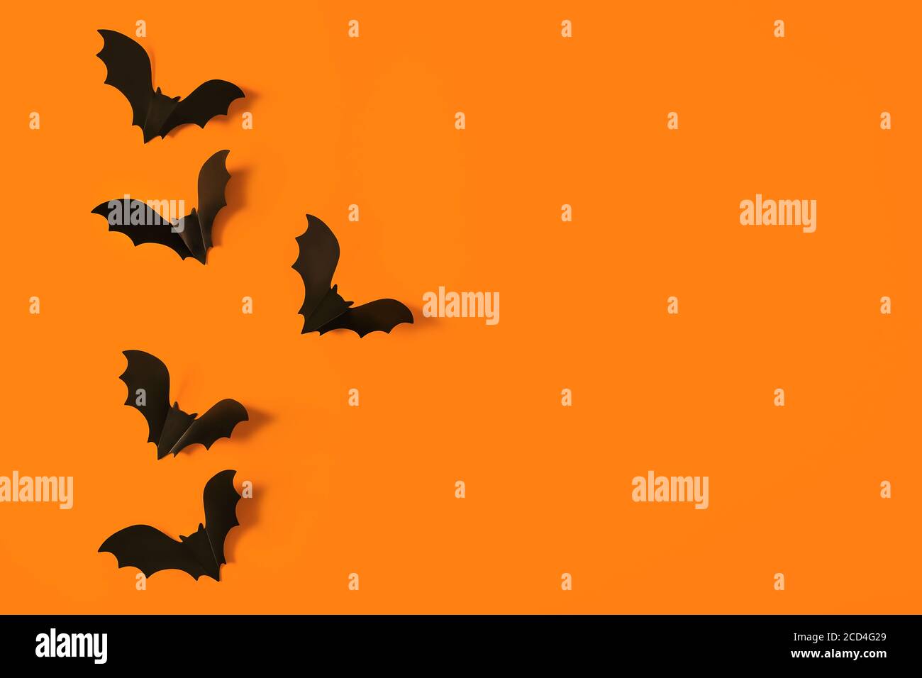 Cartoon halloween Hintergrund schwarze Fledermäuse auf orangen Hintergrund. Helle Urlaubskulisse für Ihr Design. Dunkler und launischer Hintergrund. Für Text platzieren. Stockfoto