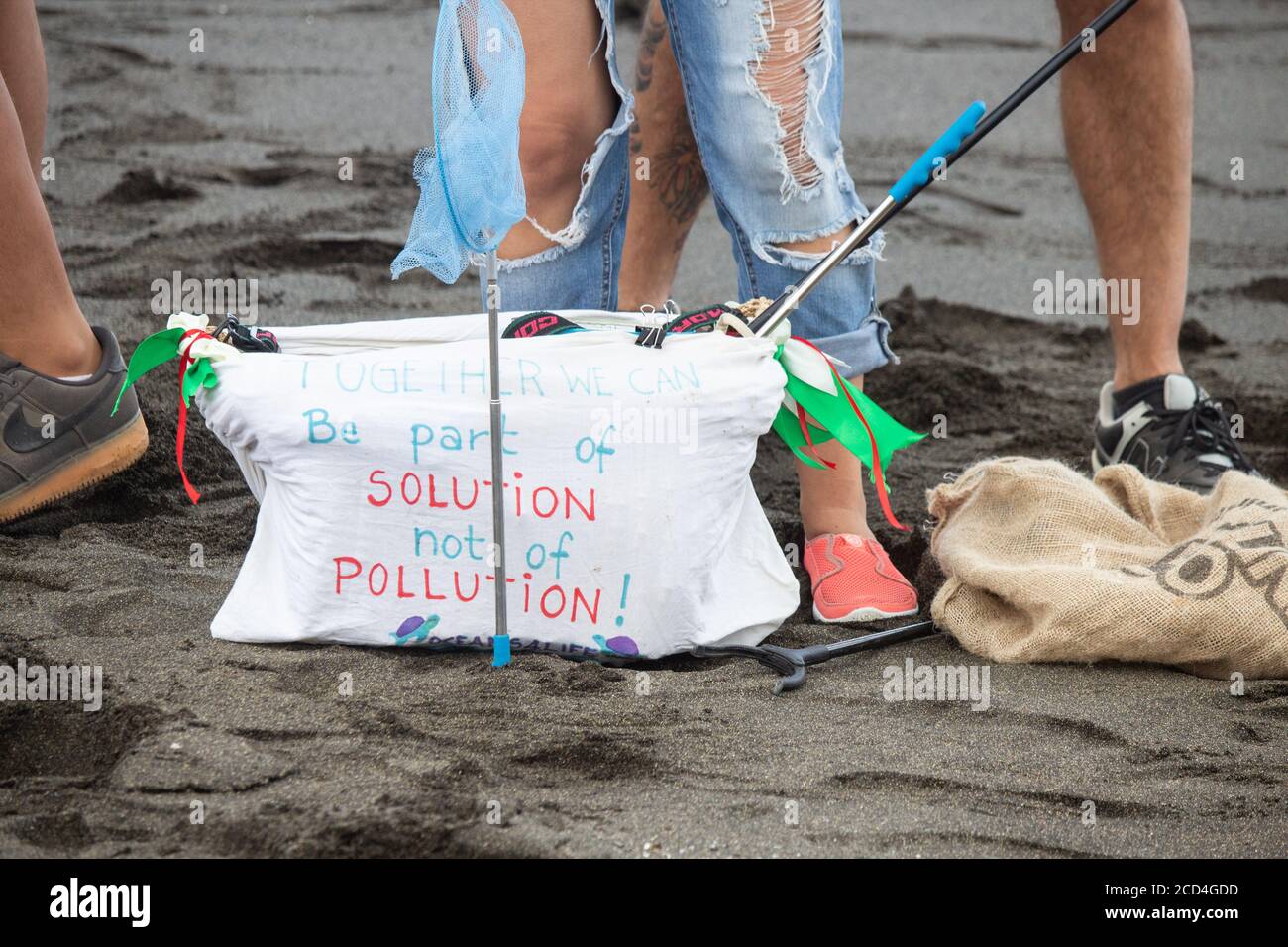 Seien Sie Teil der Lösung nicht die Verschmutzung Slogan auf Tasche während Strand sauber. Stockfoto