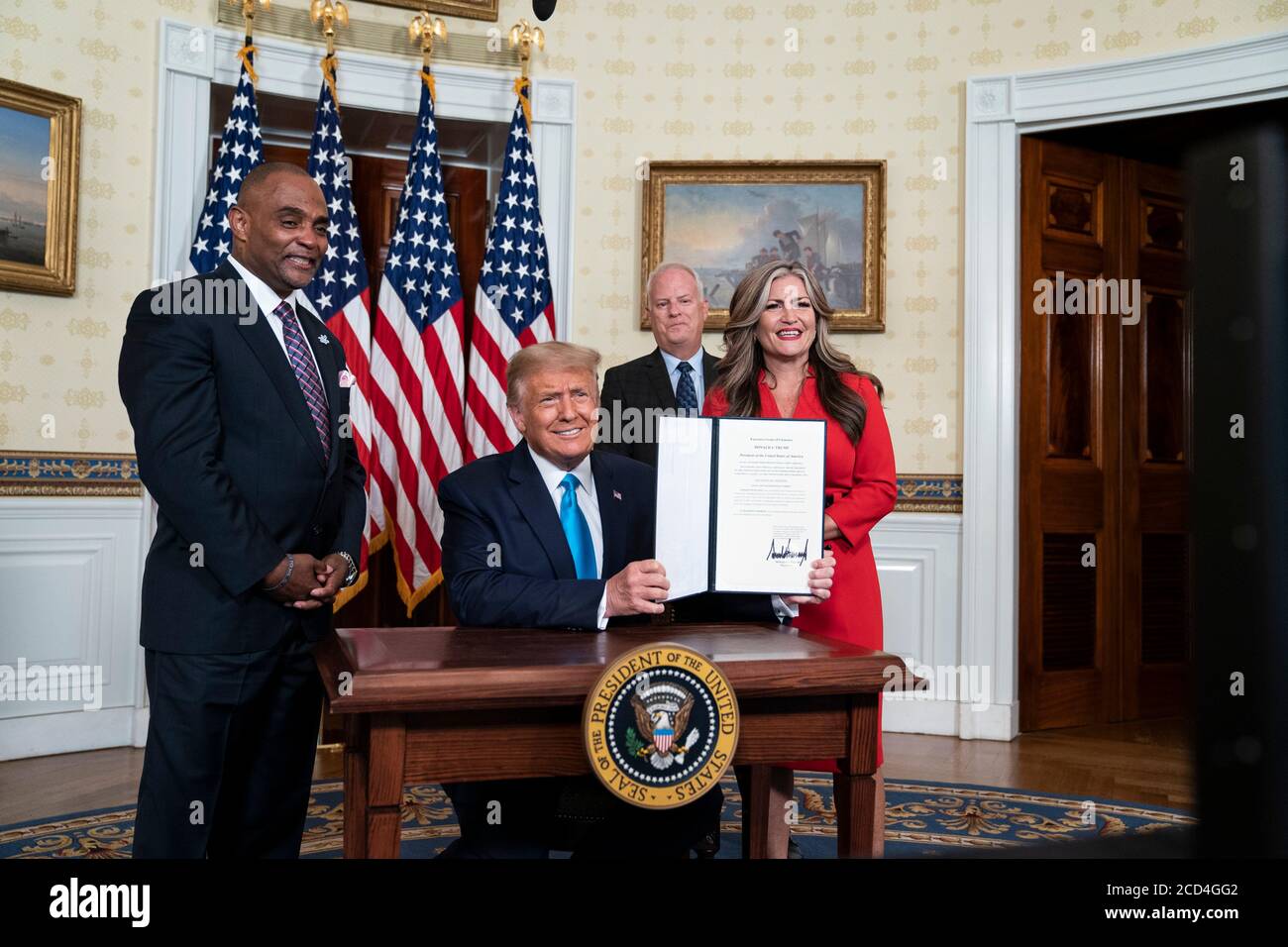 Washington, Vereinigte Staaten Von Amerika. August 2020. Washington, Vereinigte Staaten von Amerika. 25. August 2020. US-Präsident Donald Trump, zusammen mit Ex-Sträfling und Hope for Prisoners CEO Jon Ponder, Left, seine Frau Jamie und FBI-Agent Richard Beasley, zeigt seine Unterschrift nach der Unterzeichnung einer Begnadigung für Ponder im Blauen Raum des Weißen Hauses 25. August 2020 in Washington, DC. Kredit: Joyce N. Boghosian/Weißes Haus Foto/Alamy Live Nachrichten Stockfoto