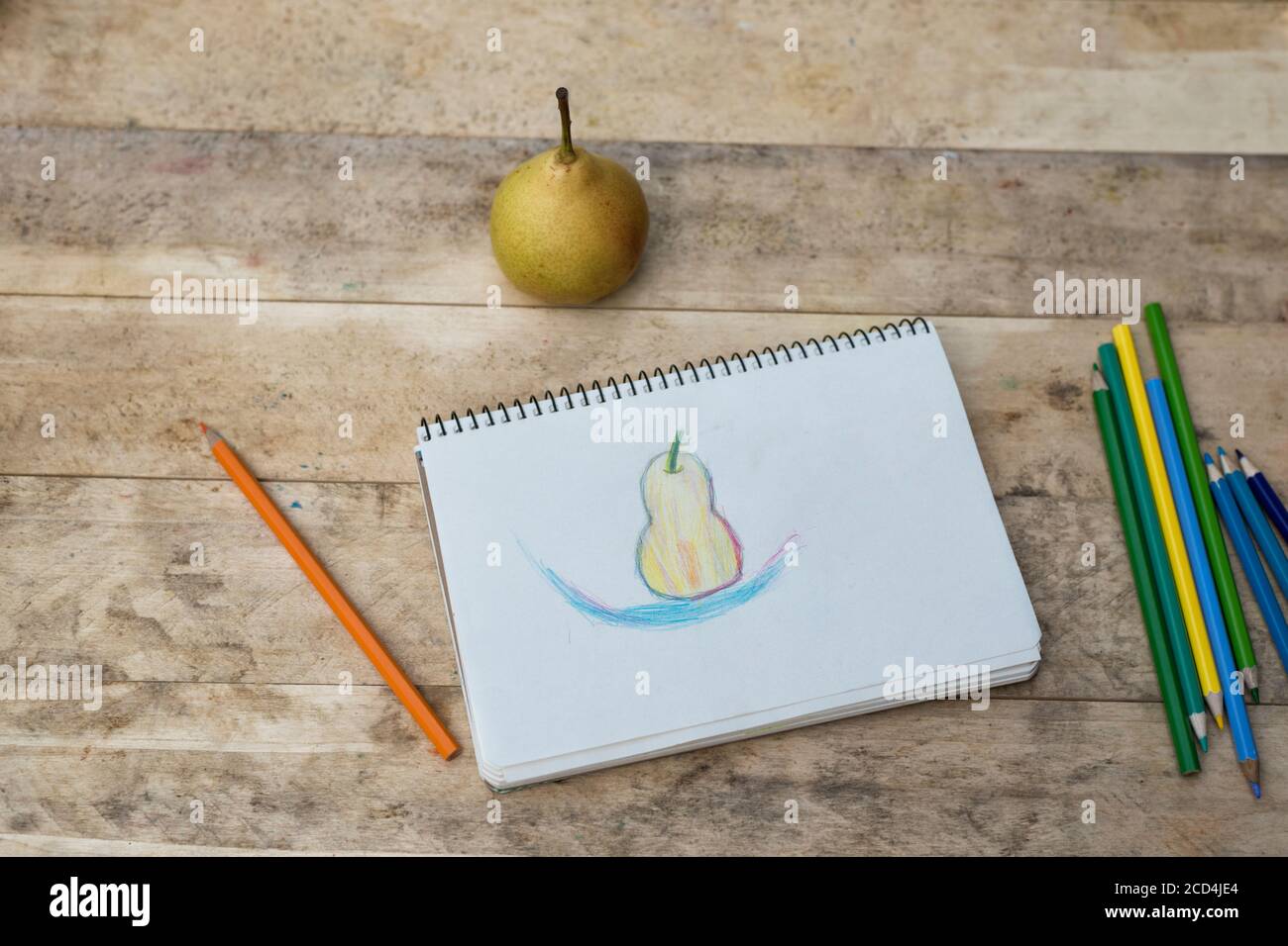 Kinderzeichnung, Birnen- und Buntstifte. Holztisch. Draufsicht Stockfoto