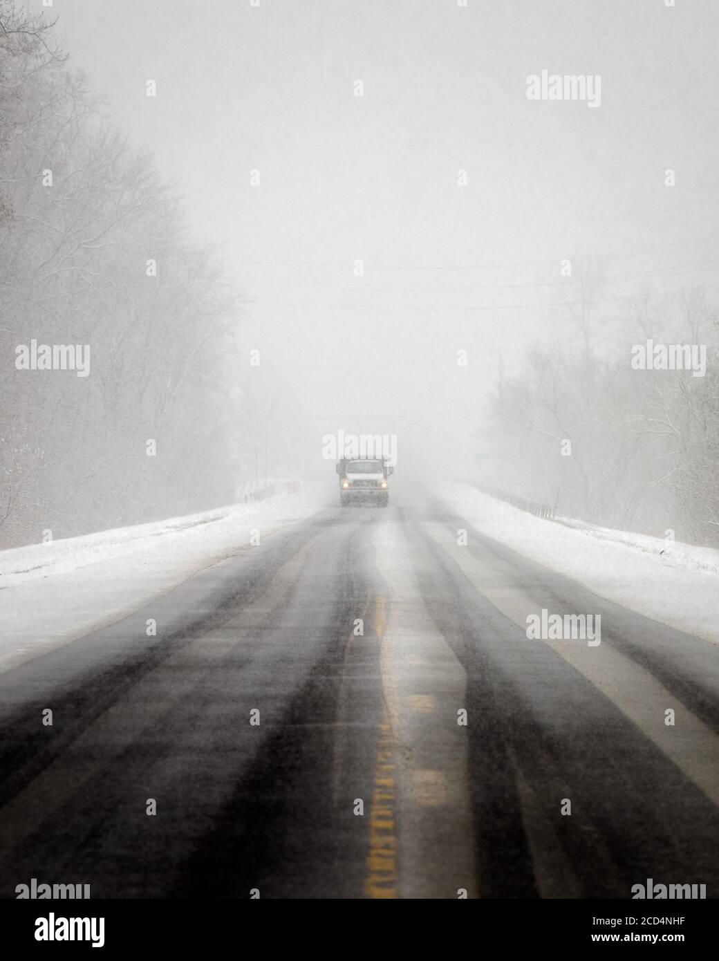 Mohawk Valley, New York State: Reduzierte Sicht während eines Schneesturms macht Reisen tückisch für diesen Einzelwagen. Stockfoto