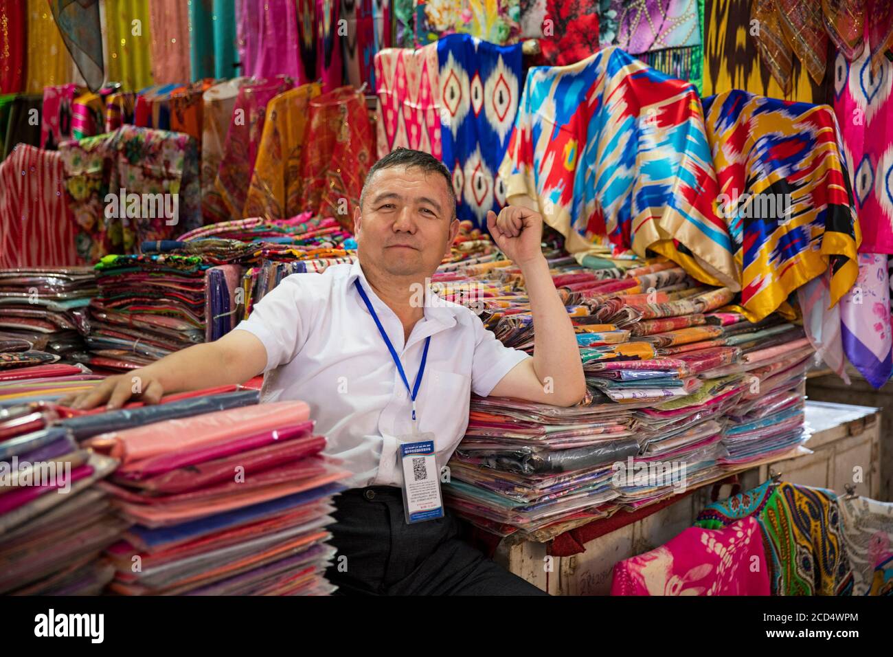 Uiguren Verkäufer Verkauf von bunten Tuch in Stoff-Shop / Draper-Shop in der Stadt Kashgar / Kashi / Kasjgar, Xinjiang, China Stockfoto