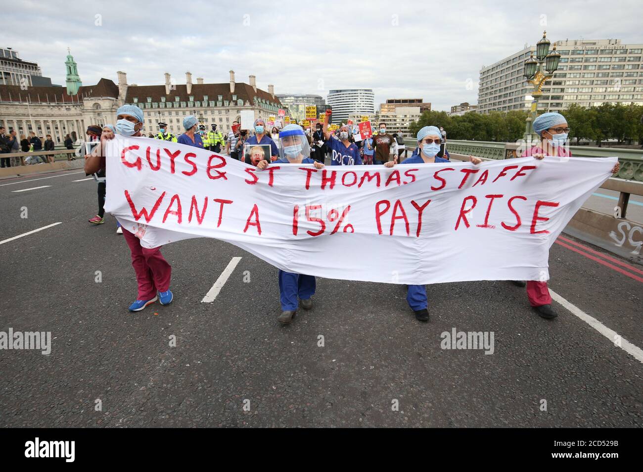 NHS-Arbeiter überqueren die Westminster Bridge, während sie während einer Kundgebung zur Downing Street in London marschieren, um von der Regierung eine Lohnerhöhung von 15 Prozent zu fordern. Stockfoto