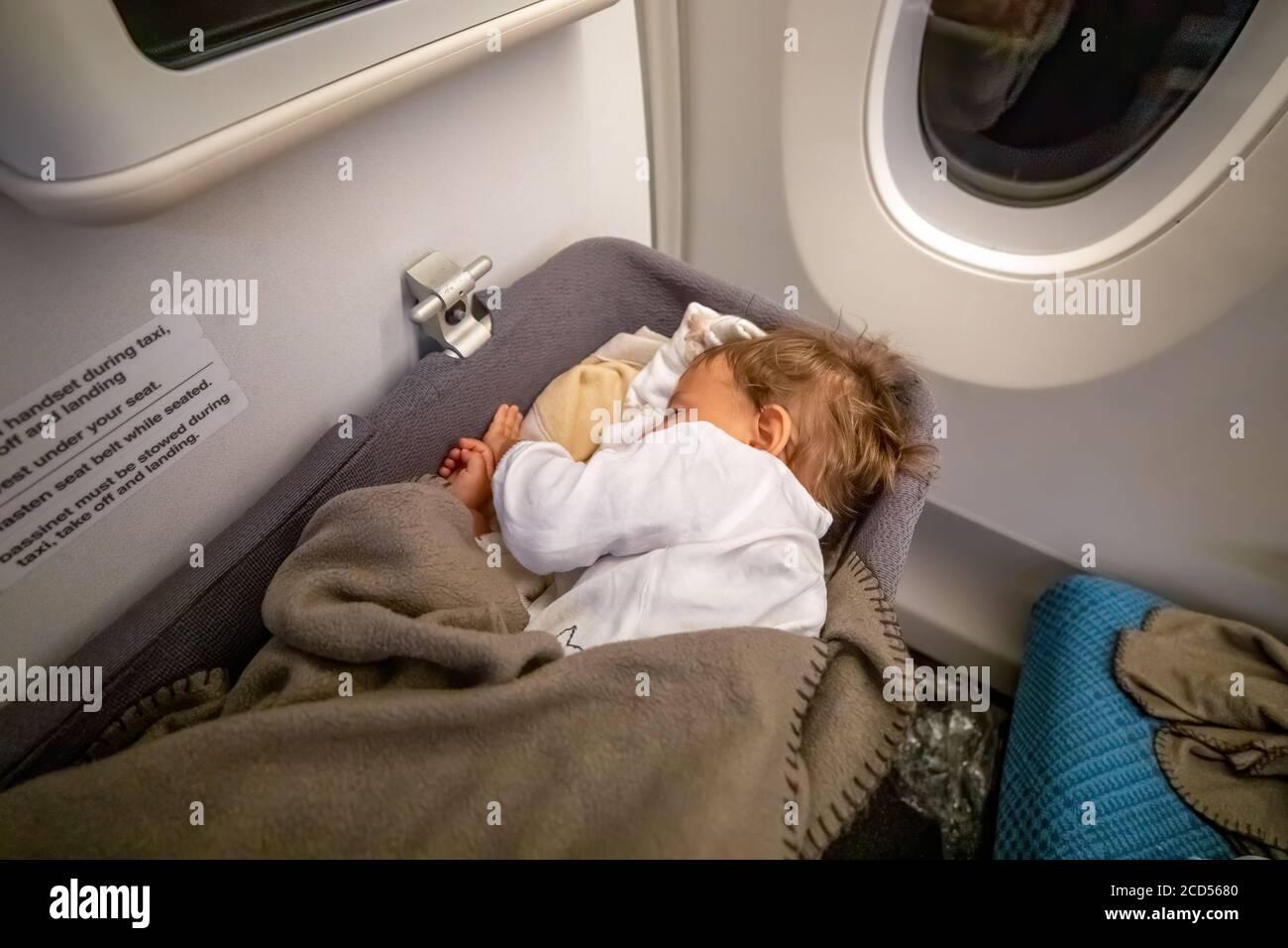 Kleine zwei Jahre alte Mädchen schlafen in einer Liegewanne Im Flugzeug Stockfoto