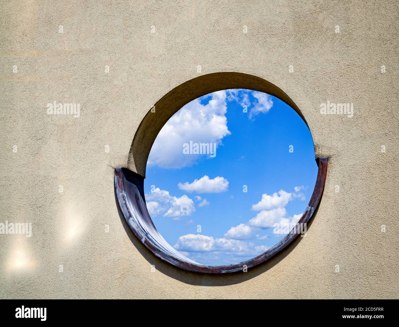 Blick auf den Himmel durch ein rundes Fenster Stockfoto