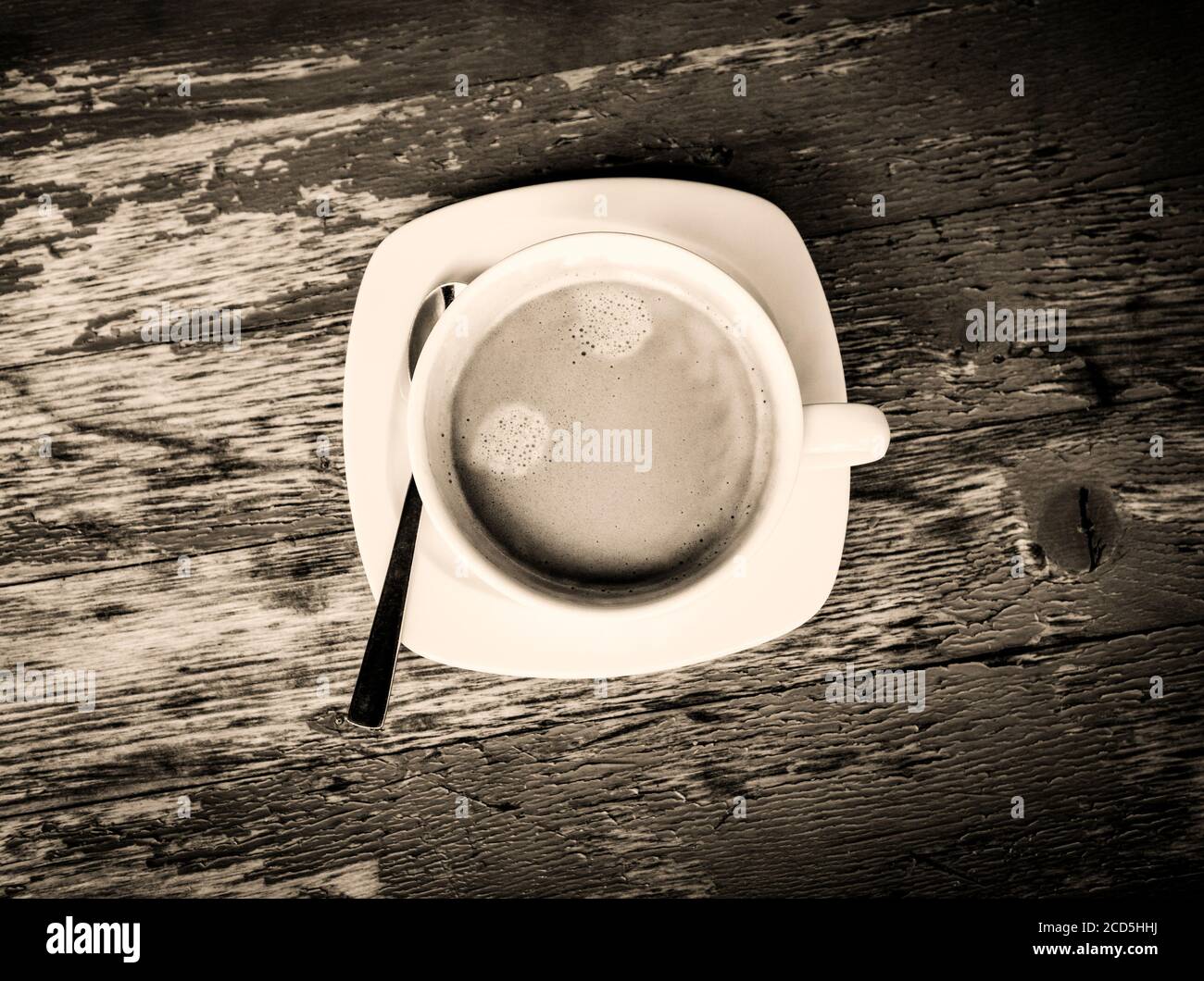 Schwarz-Weiß-Ansicht der frischen Tasse Kaffee auf Ein verwitterter Tisch von oben Stockfoto