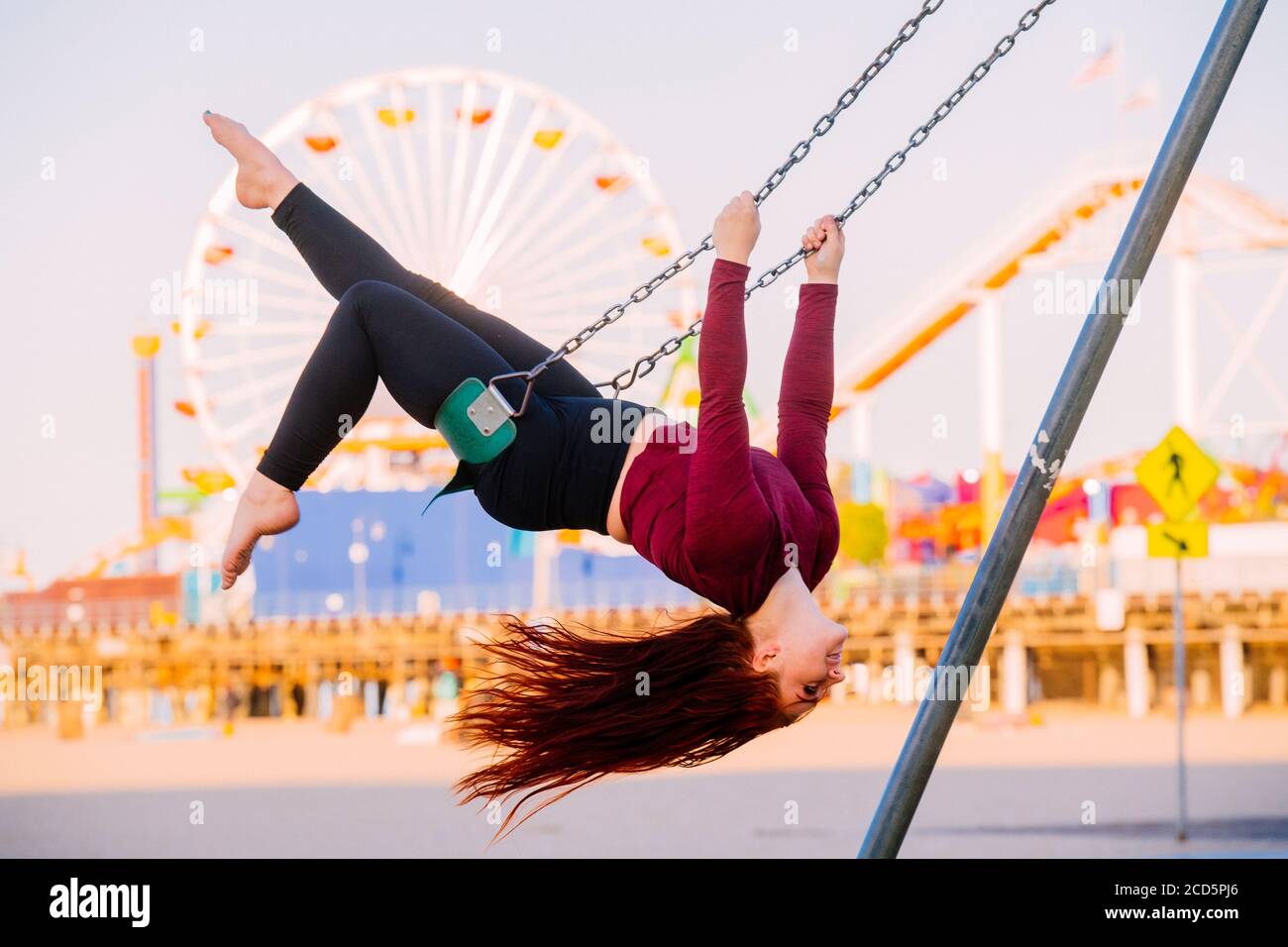 Weibliche flugakrobatin auf Schaukel am Strand in der Nähe von Santa Monica Pier, Santa Monica, Kalifornien, USA Stockfoto