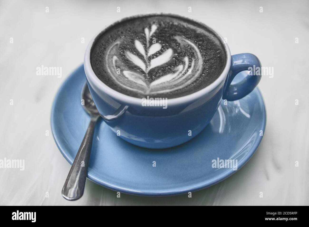 Charcoal Latte Kaffeetasse Aktivkohle schwarzes Pulver gemischt Cappuccino Milchschaum für gesunde Entgiftung Kater Heilung amerikanischen Trend Stockfoto