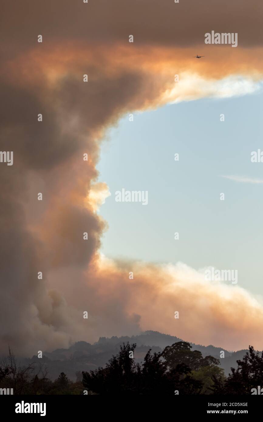 Wir werden uns nicht ausruhen - Feuerflugzeuge kommen um für einen anderen Durchgang, während Rauch aggressiv steigt. Santa Rosa, Kalifornien, USA Stockfoto