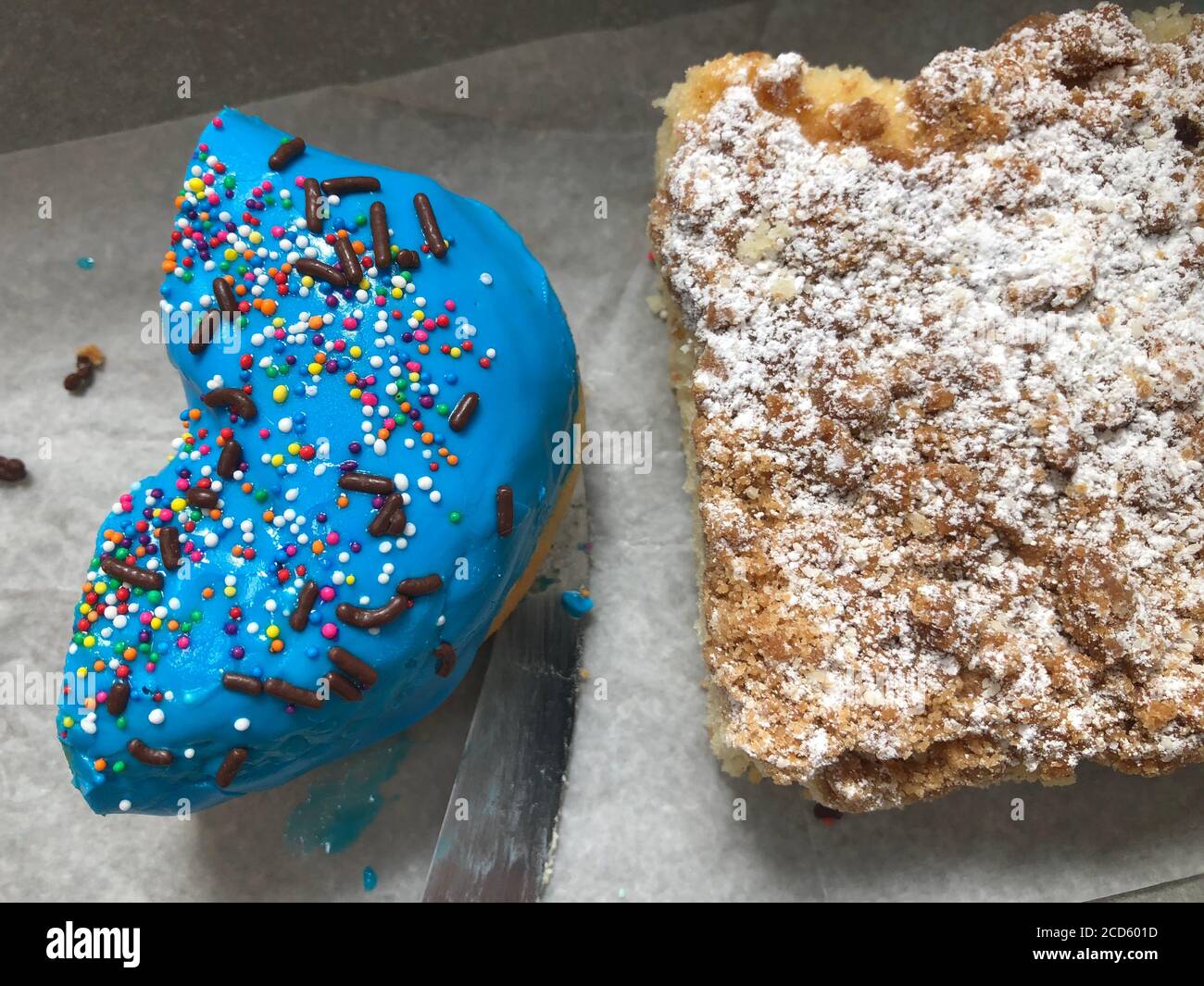 Zuckerhaltige blaue Puderdonut und Kuchen auf dem Tisch Stockfoto