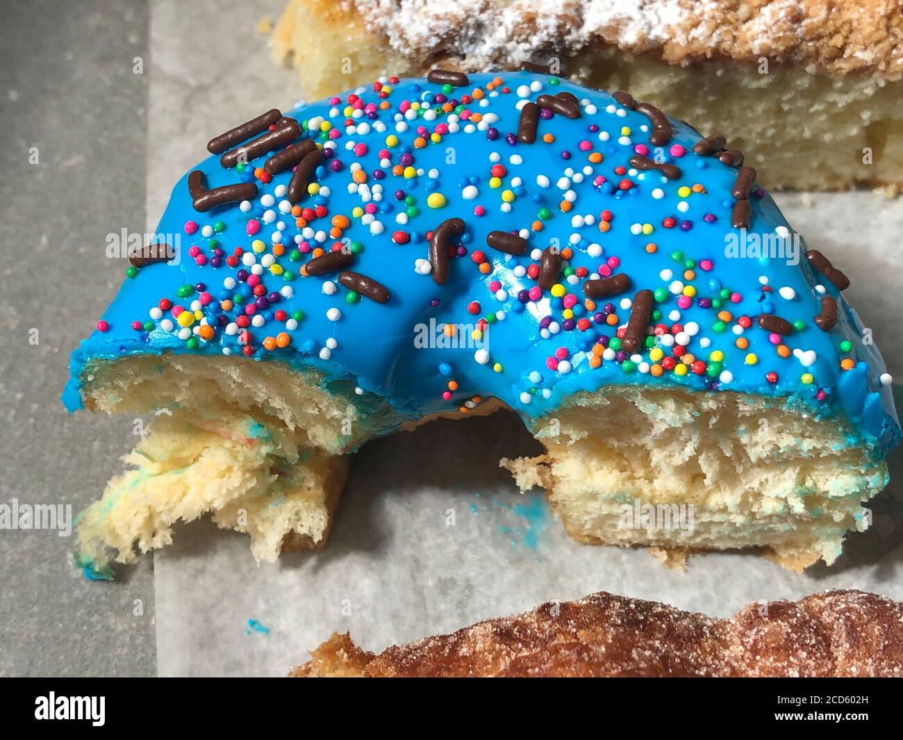 Halb gefressen Donut mit blauer Glasur und bunten Streuseln Stockfoto