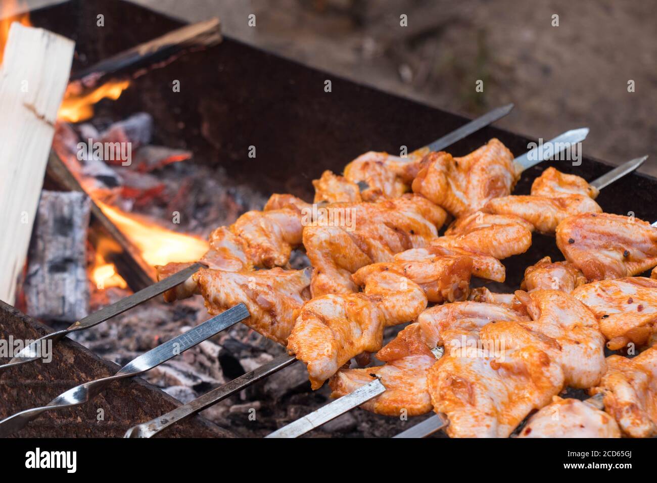 Thema des Abendessens im Freien. Saftig geröstete Kebabs auf dem Grill. Hühnerfleisch auf Spieße. Stockfoto