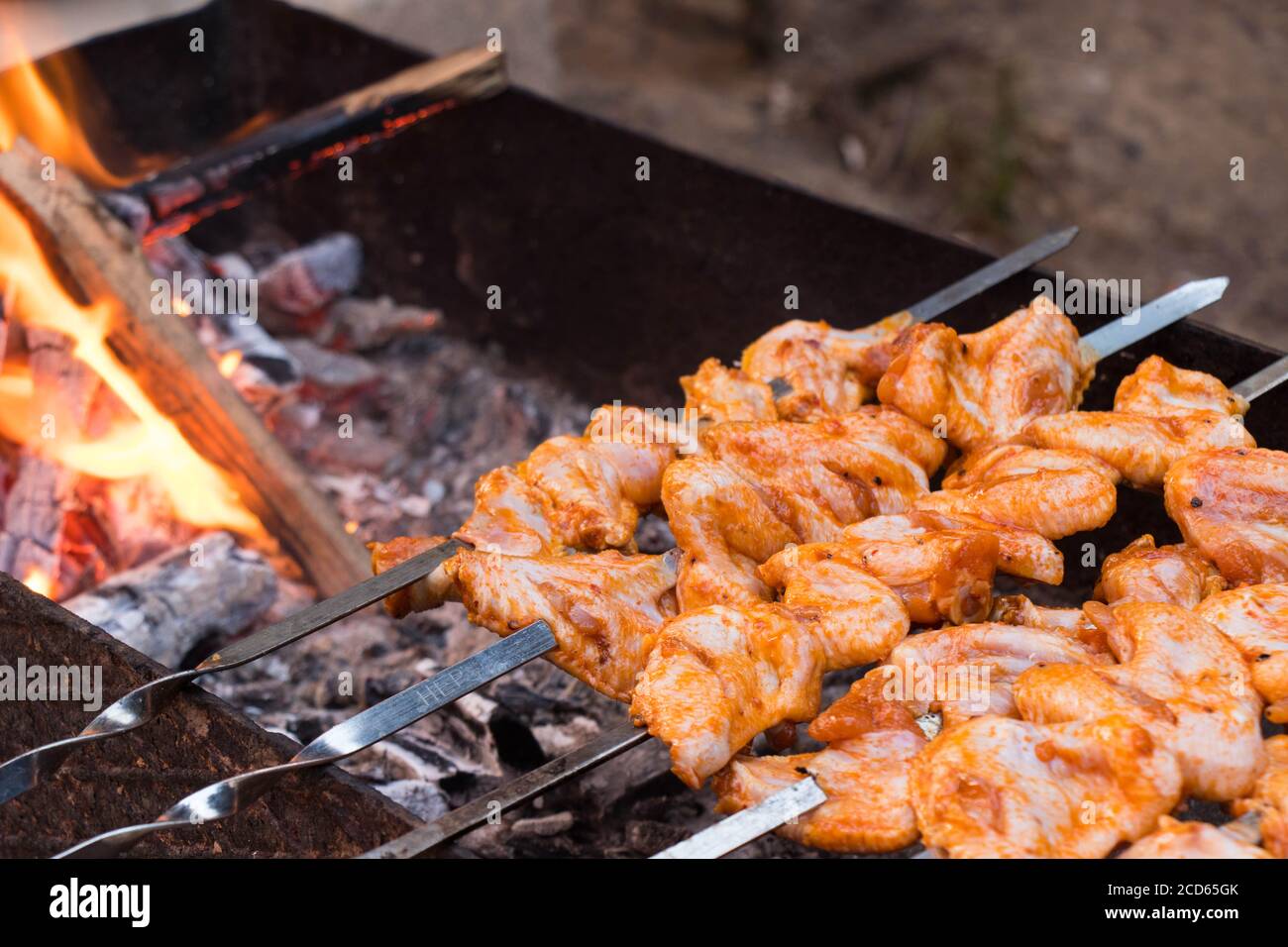 Thema des Abendessens im Freien. Saftig geröstete Kebabs auf dem Grill. Hühnerfleisch auf Spieße. Stockfoto