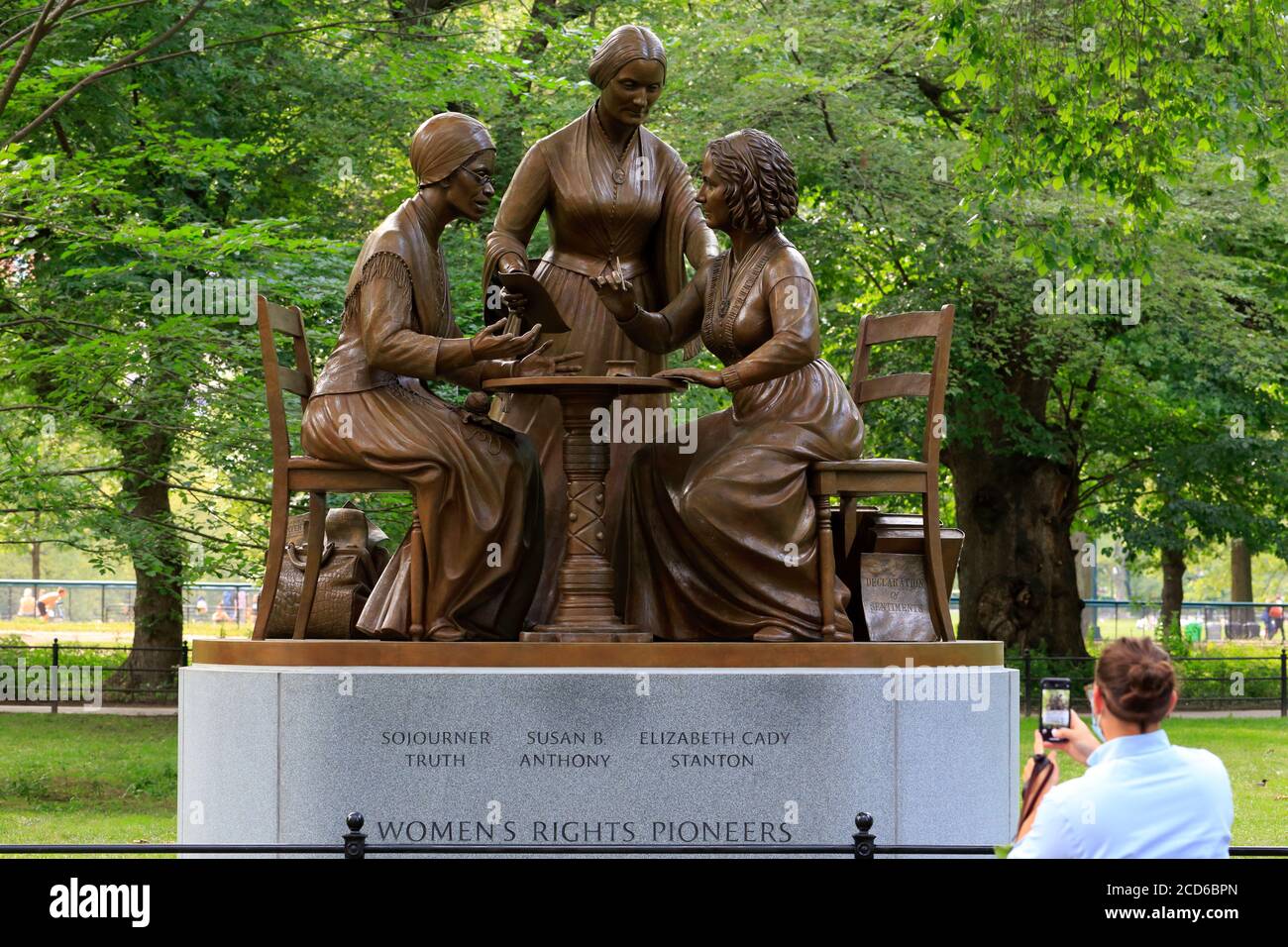 Eine Person nimmt ein Telefonfoto der Bronzestatue der 'Women’s Rights Pioneers' auf, einer Skulptur von Meredith Bergmann im Central Park, New York, NY. Stockfoto