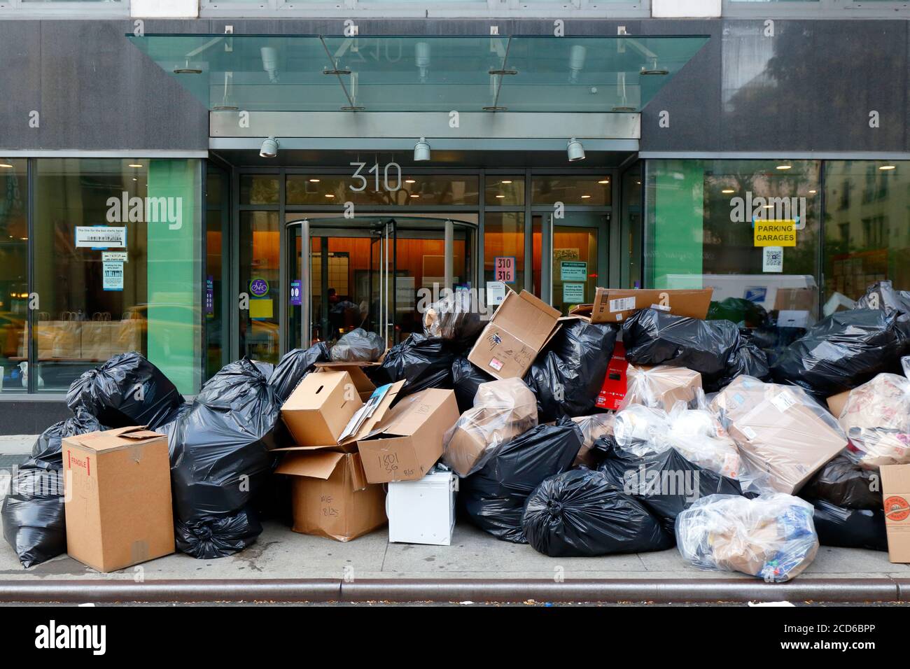 Hausmüll und Müll stapelten sich vor einem Wohngebäude in New York City und warteten auf die Abholung und Entsorgung durch das Ministerium für Sanitär. Stockfoto