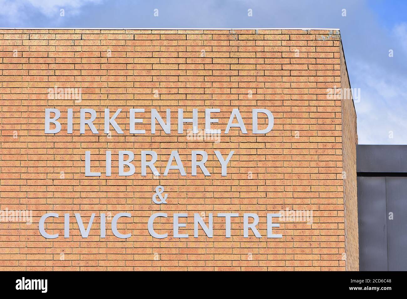 Gelbe Ziegelfassade mit Schild in Großbuchstaben der Birkenhead Library und des Civic Center. Stockfoto