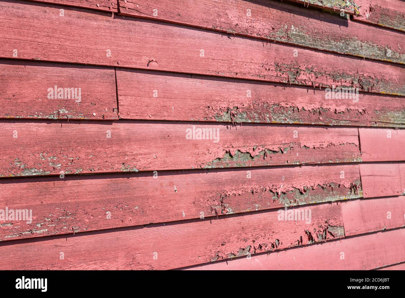 Nahaufnahme Textur Hintergrundansicht eines antiken Holz Runde Seitenwand mit rauer verwitterter Oberfläche und abblätternder roter Farbe Stockfoto