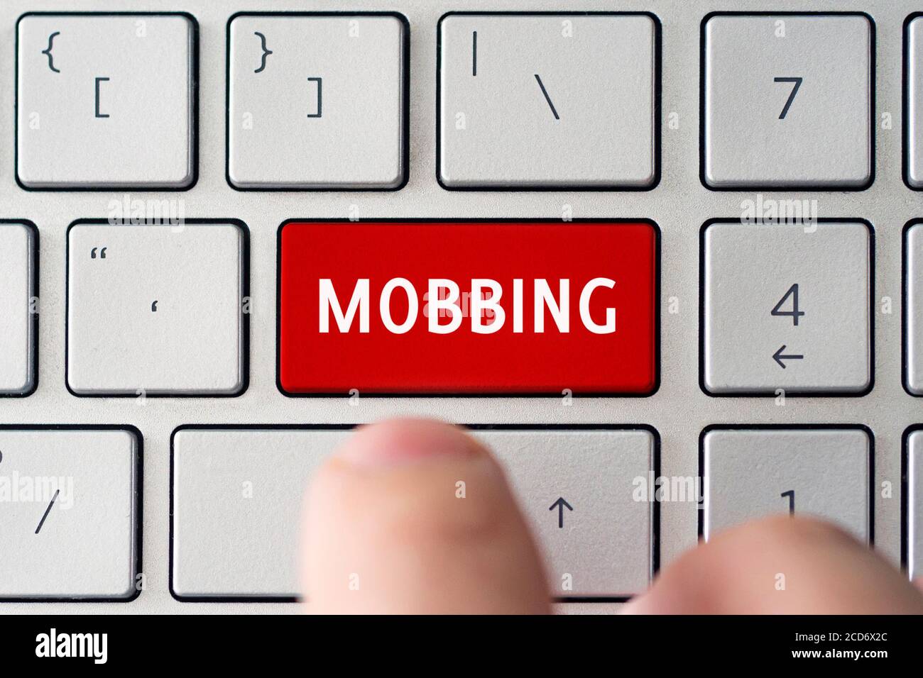 Wortschulden auf der grauen Tastatur des Computers. Das Konzept der Belästigung Einschüchterung und Erniedrigung im Netzwerk. Stockfoto