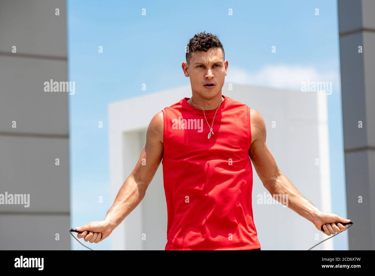 Schöner kaukasischer Athlet tun Morgen Outdoor-Übung springen Seil auf Dach des Gebäudes Stockfoto