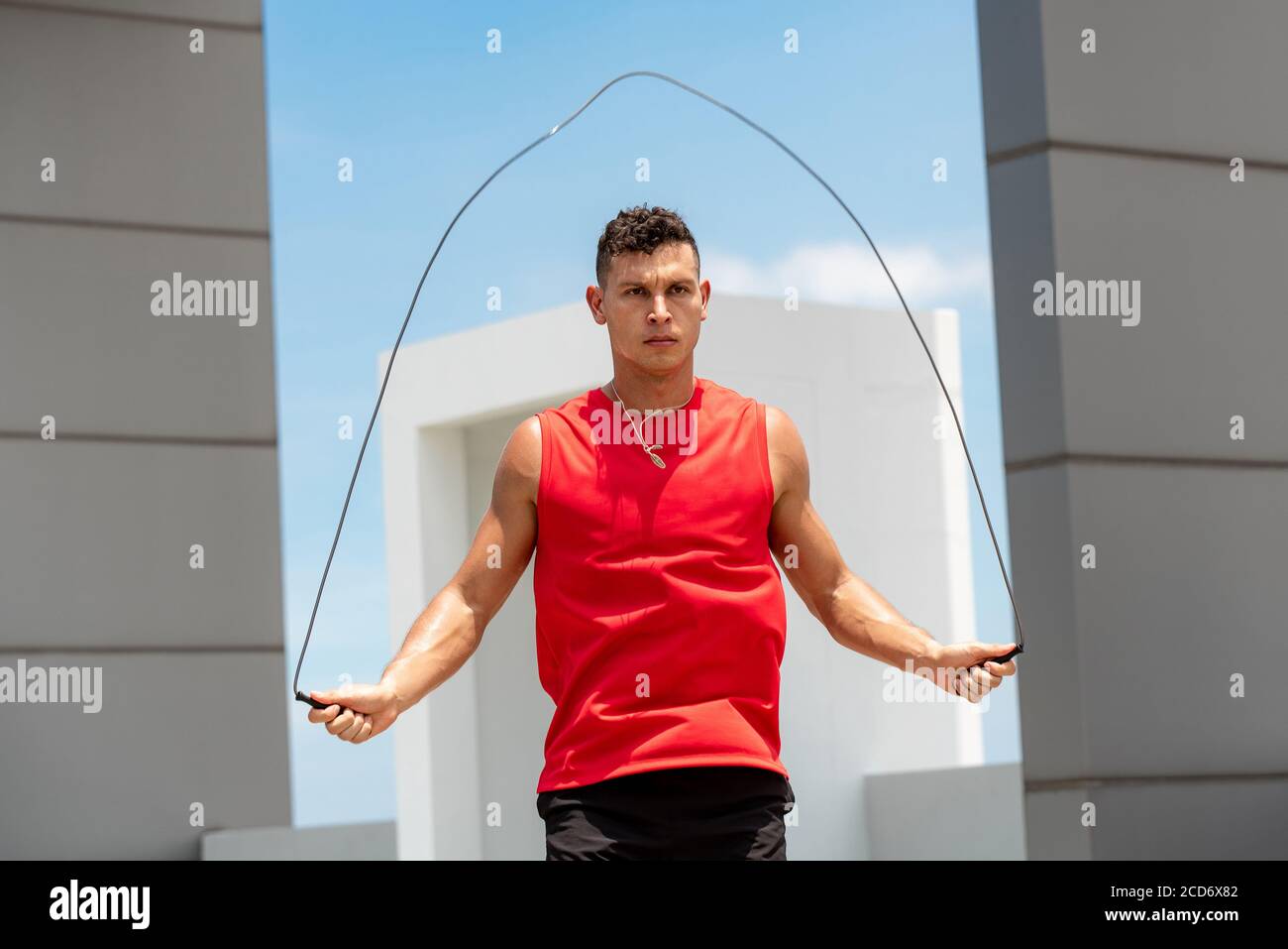 Schöner kaukasischer Athlet tun Morgen Outdoor-Übung springen Seil auf Dach des Gebäudes Stockfoto