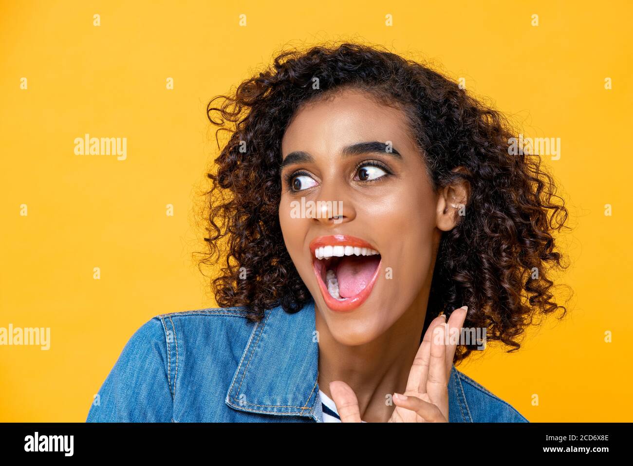 Fun Nahaufnahme Porträt von jungen überrascht afroamerikanische Frau Mit offenem Mund auf Studio-gelbem Studiohintergrund Stockfoto