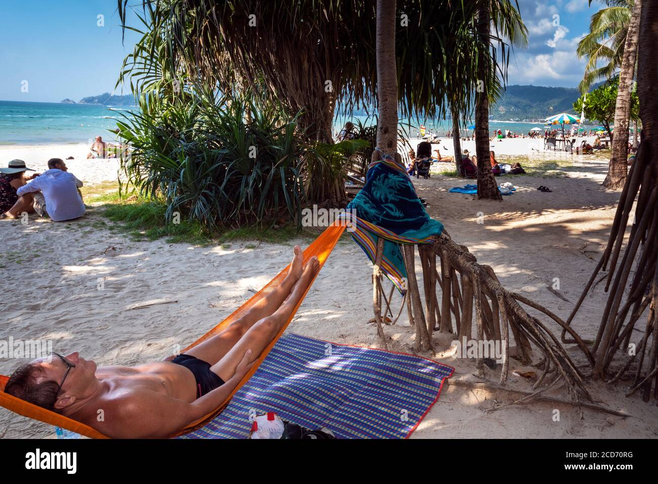 Tourist relaxen in einer Hängematte am Strand von Patong, Phuket, Thailand Stockfoto