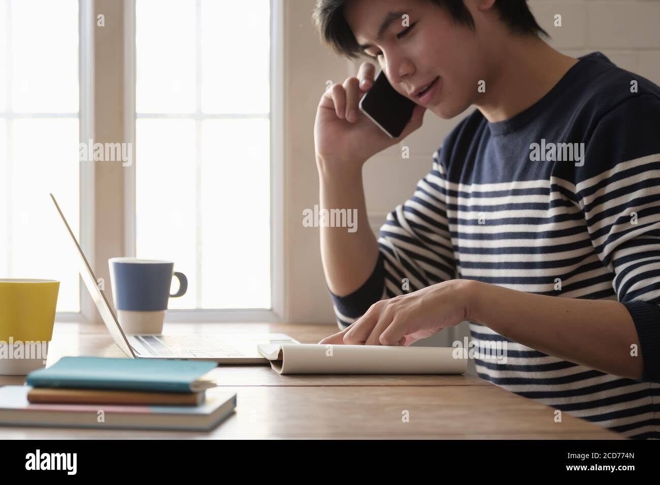 Glücklicher junger Mann lernen Sprache hören Vortrag sehen Webinar schreiben Notizen Blick auf Laptop sitzen zu Hause, Fernunterricht Stockfoto