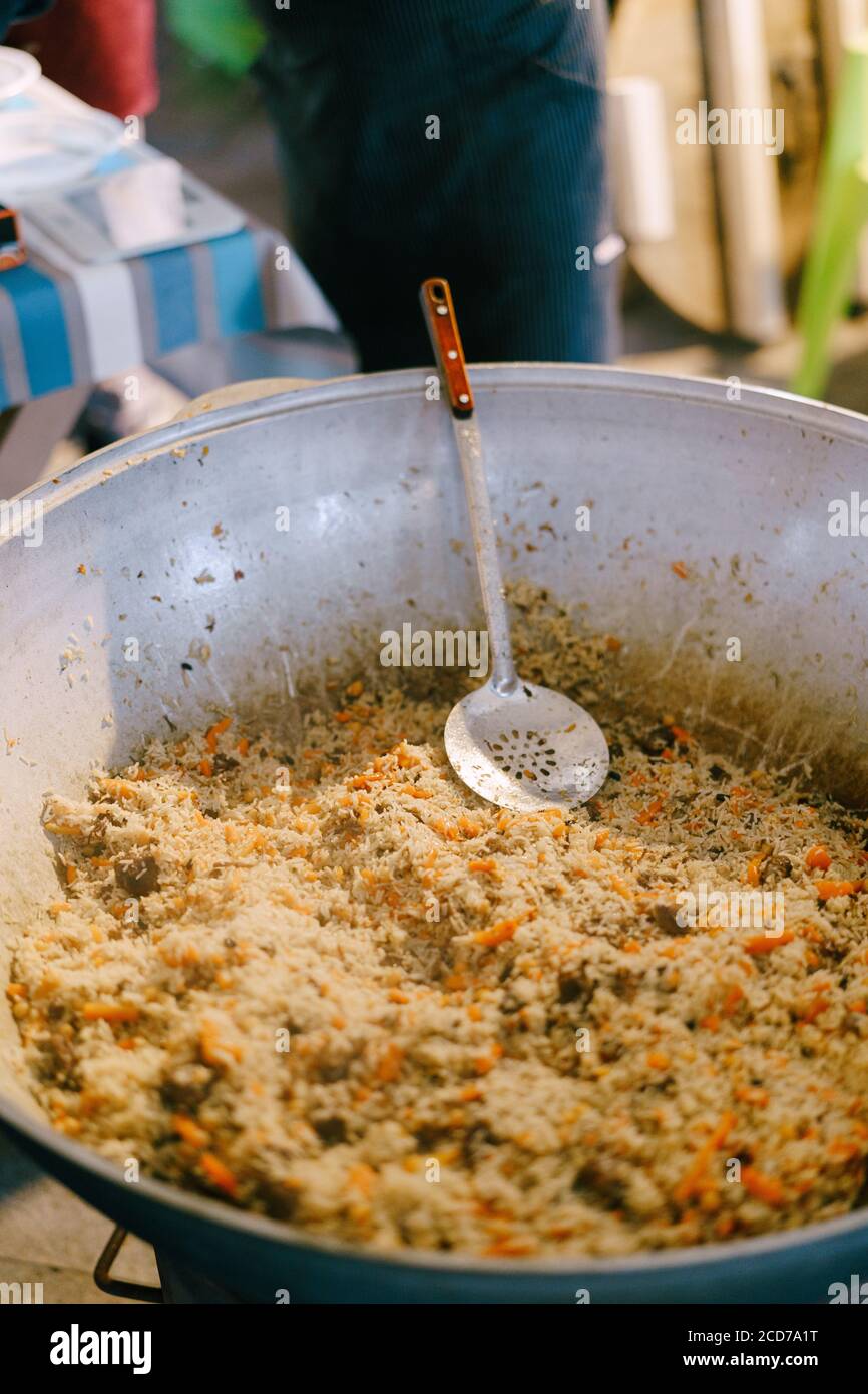 Ein riesiger Kessel mit Textur usbekischer Pilaf. Stockfoto