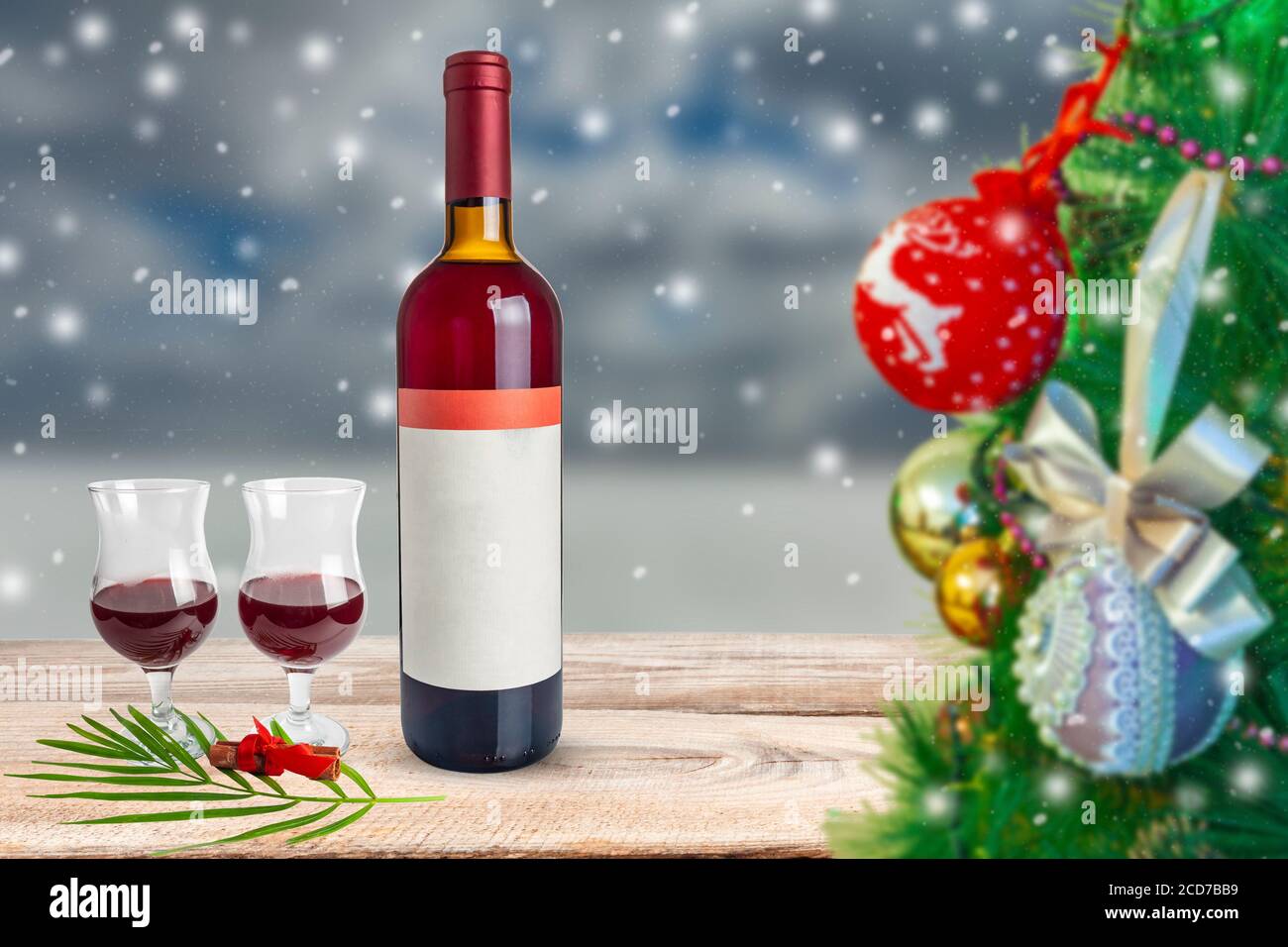 Thema „Neujahr“. Weinflasche mit Gläsern Wein auf dem Hintergrund von fallendem Schnee. Stockfoto