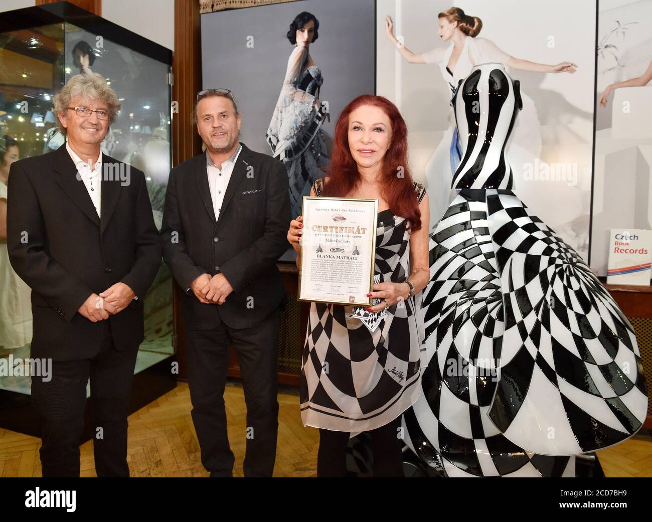 Prag, Tschechische Republik. August 2020. Die tschechische Modedesignerin Blanka Matragi, rechts, posiert mit ihrem Glaskleid während einer Pressekonferenz über ihren Eintritt in die Record Hall of Fame des Museums für Schallplatten und Kuriositäten mit dem Glaskleid, das am 27. August 2020 auch in das Tschechische Buch der Schallplatten aufgenommen wird. Auf der linken Seite sehen Sie Miroslav Marek, links, und Lubos Rafaj von der Agentur, die das Buch veröffentlicht. Kredit: Michaela Rihova/CTK Foto/Alamy Live Nachrichten Stockfoto