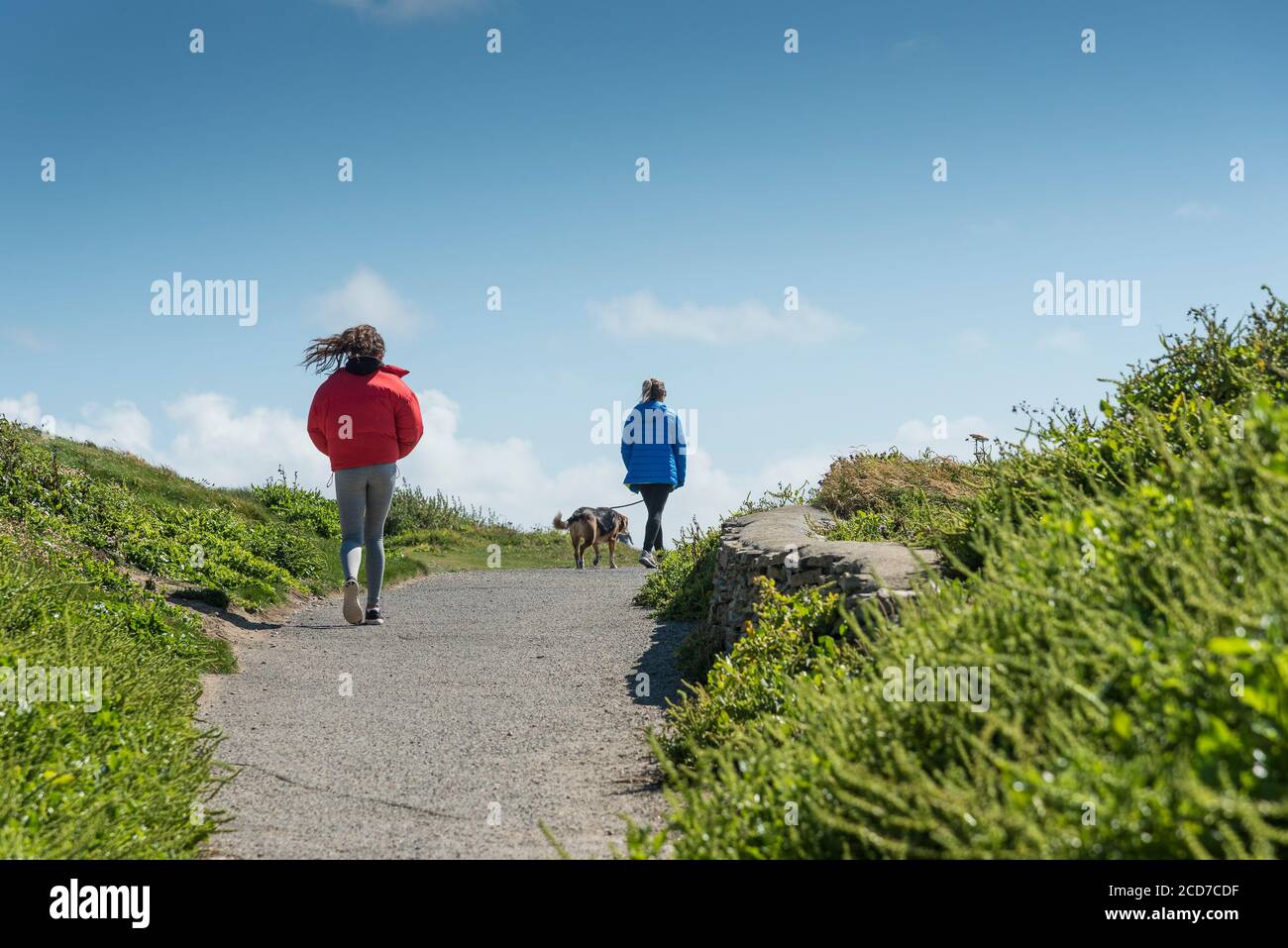 Menschen, die bei windigem Wetter einen Pfad entlang gehen. Stockfoto