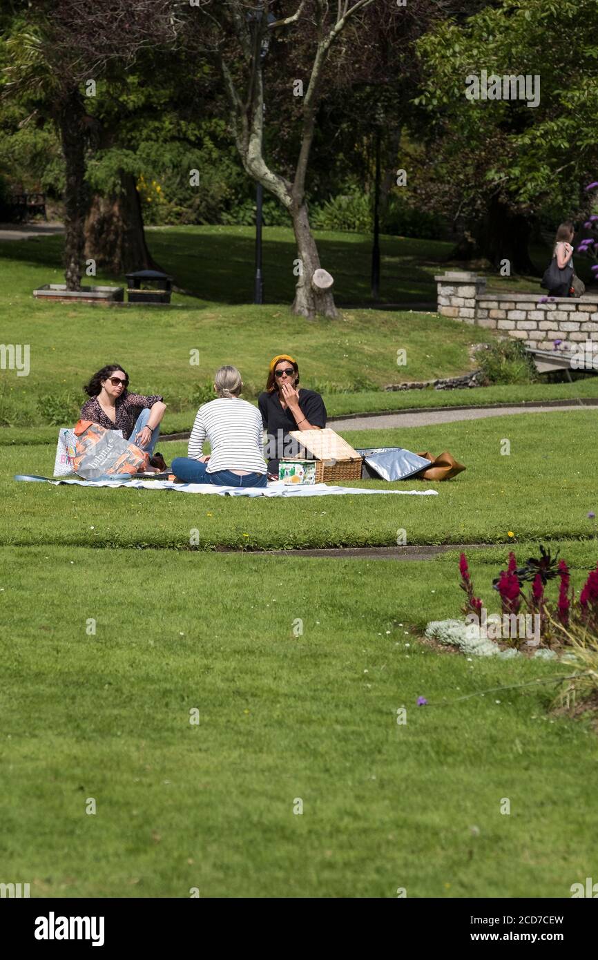 Drei Freundinnen genießen ein Picknick in den subtropischen Trenance Gardens in Newquay in Cornwall. Stockfoto