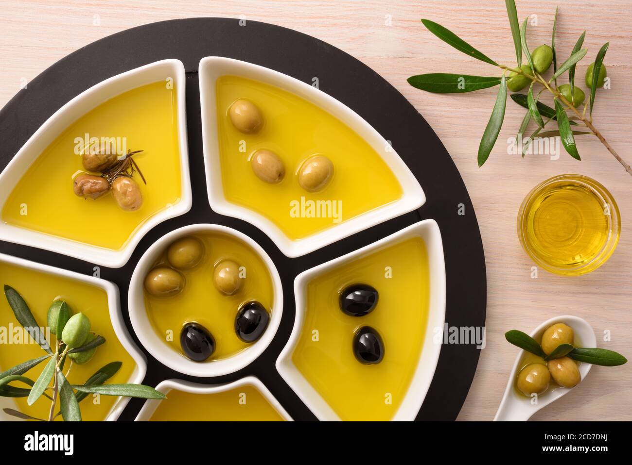 Verschiedene Varianten von Oliven zu essen und Öl in Behältern auf Holz Küchenbank. Draufsicht. Stockfoto