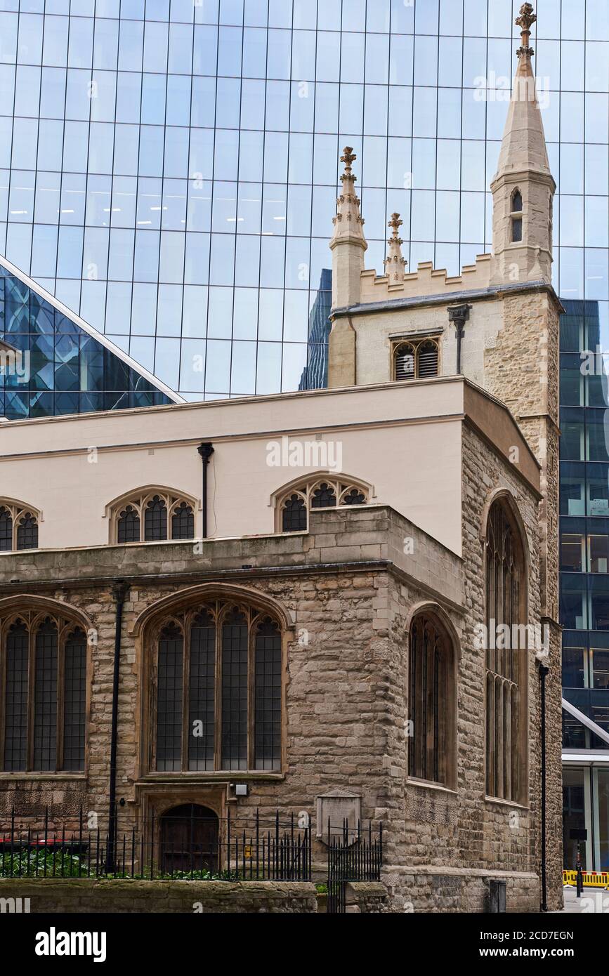 Der Turm der St. Andrew Undershhaft Kirche in der Nähe von Aldgate, in der City of London UK, aus dem Jahr 1532, von einem modernen Bürogebäude in den Schatten gestellt Stockfoto