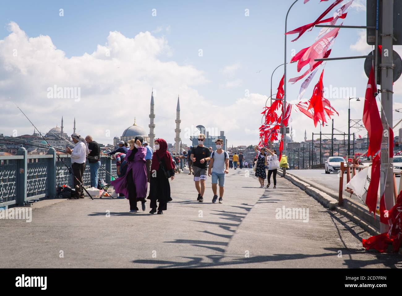 ISTANBUL / TÜRKEI - 07.17.2020: Menschen fischen und wandern auf der Golden Horn (Halic) Brücke, die Yeni Moschee im Hintergrund, Eminonu. Stockfoto