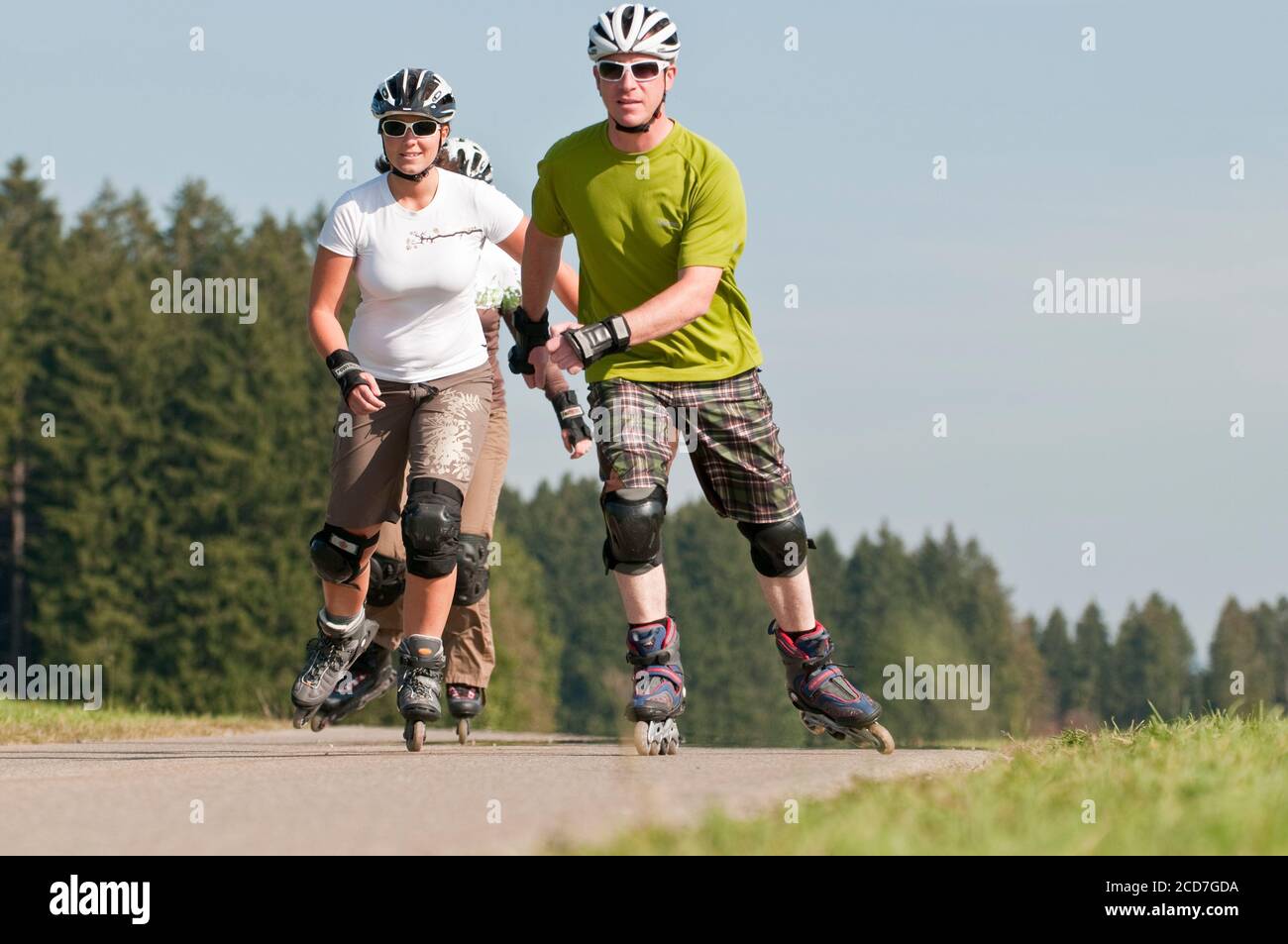 Gruppe, die eine Tour auf Rollerblätter auf einem kleinen Auf dem Land Stockfoto