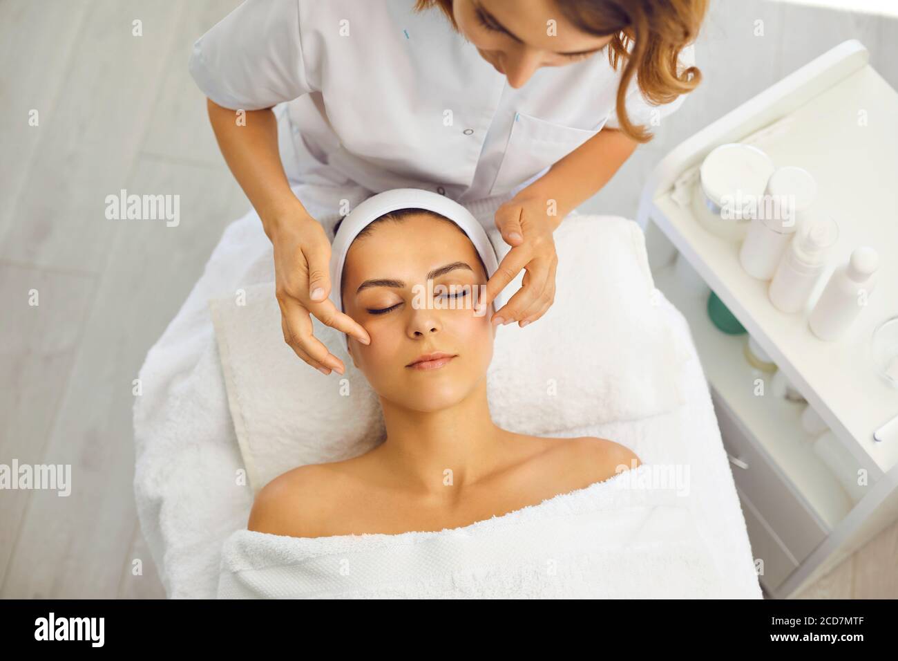 Kosmetik- oder Dermatologe Putting Creme während Gesichtsmassage für Frau Im Schönheitssalon Stockfoto