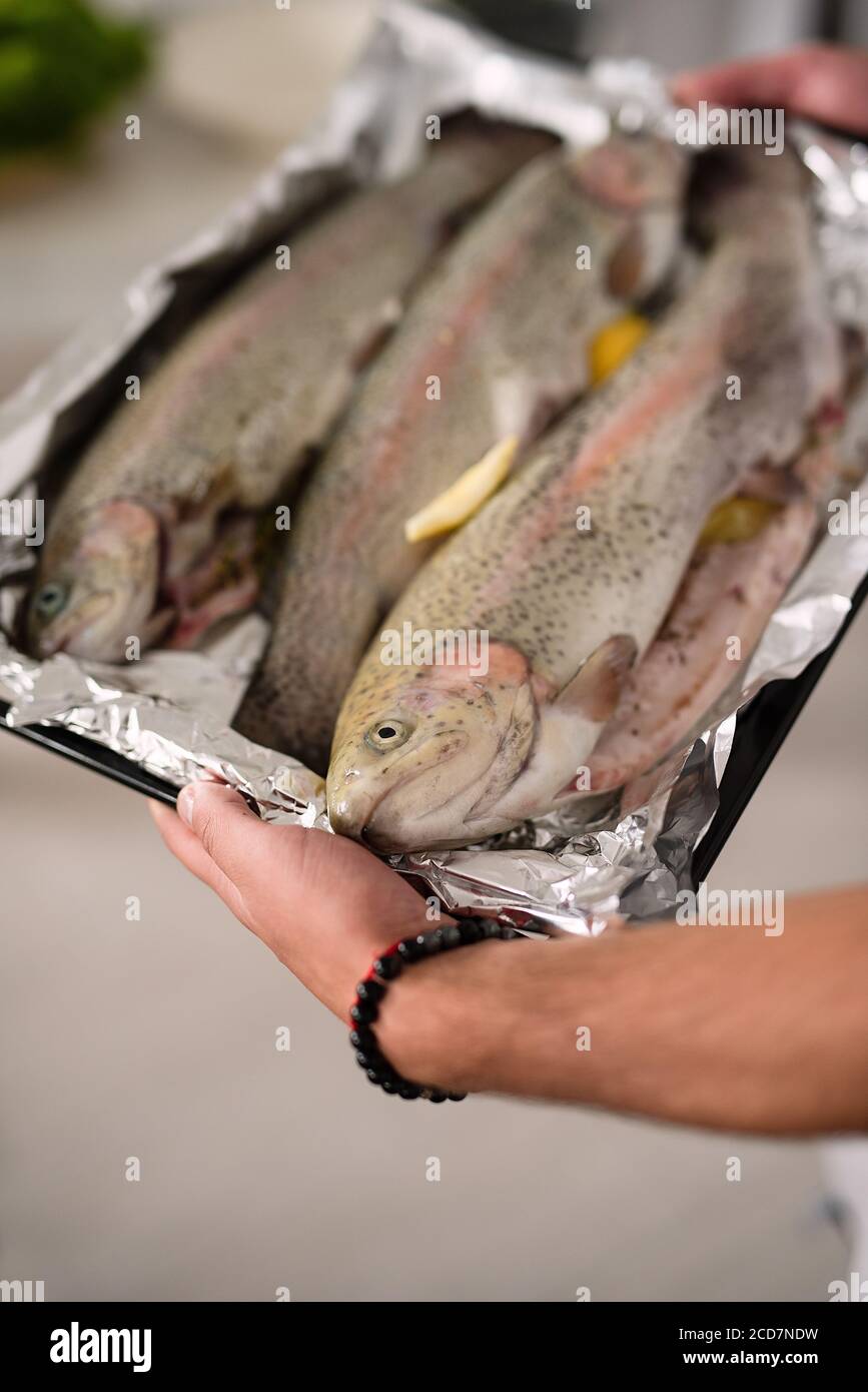 Starke männliche Hände halten Tablett mit gebackenen Fisch, gesunde Ernährung Konzept Stockfoto