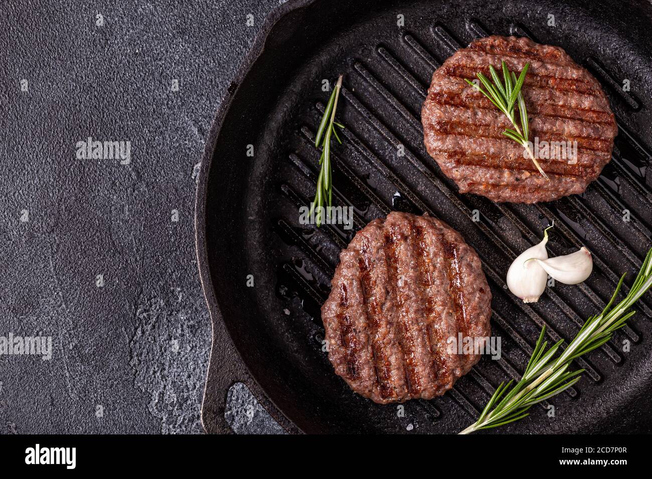 Gebratenes Schnitzel für Burger mit Gewürzen auf Grillpfanne, Draufsicht, Kopierraum. Stockfoto