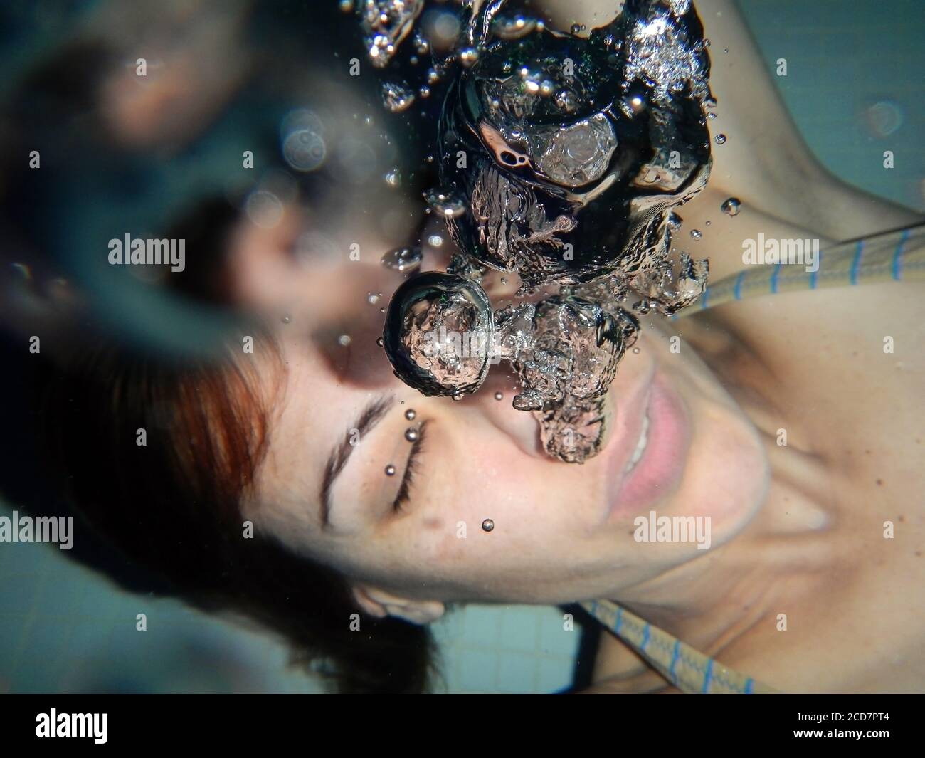 Frau unter Wasser mit Blasen. Stockfoto