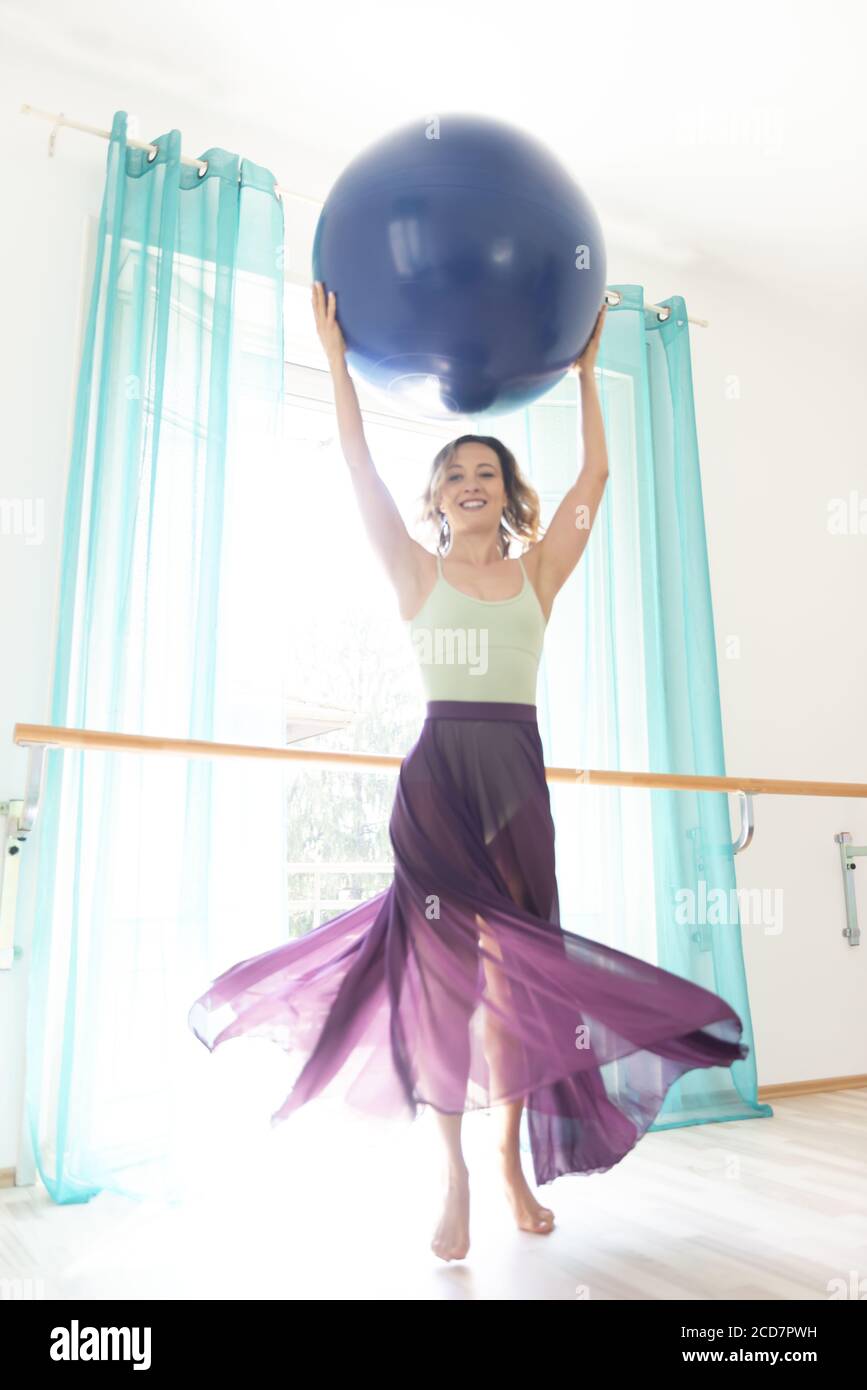 Frau hält einen blauen Ball mit transparentem Rock. Stockfoto