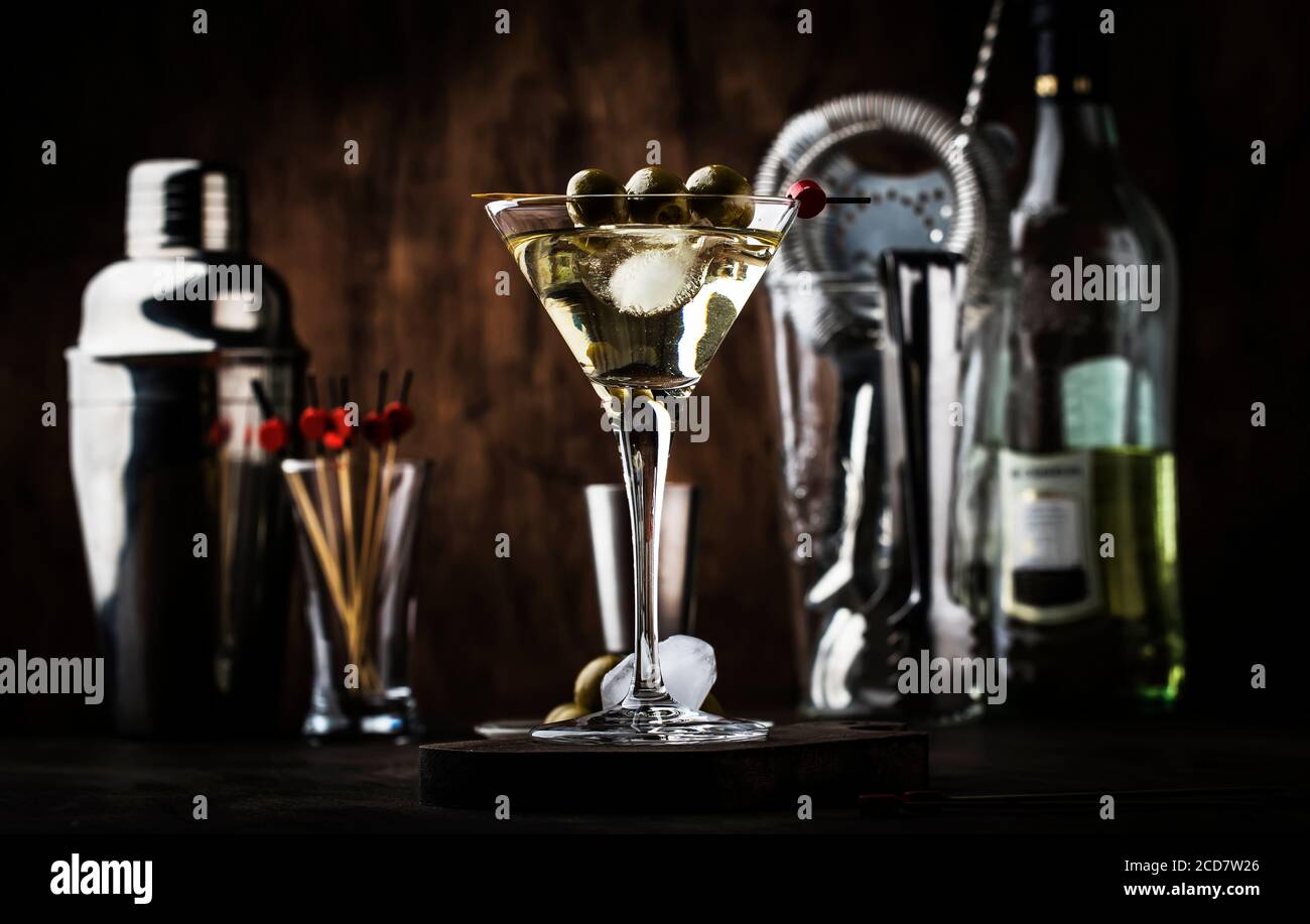 Martini Wodka Cocktail, mit trockenem Wermut, Wodka und grünen Oliven, Bar Werkzeuge, Vintage Holztheke, selektiver Fokus Stockfoto