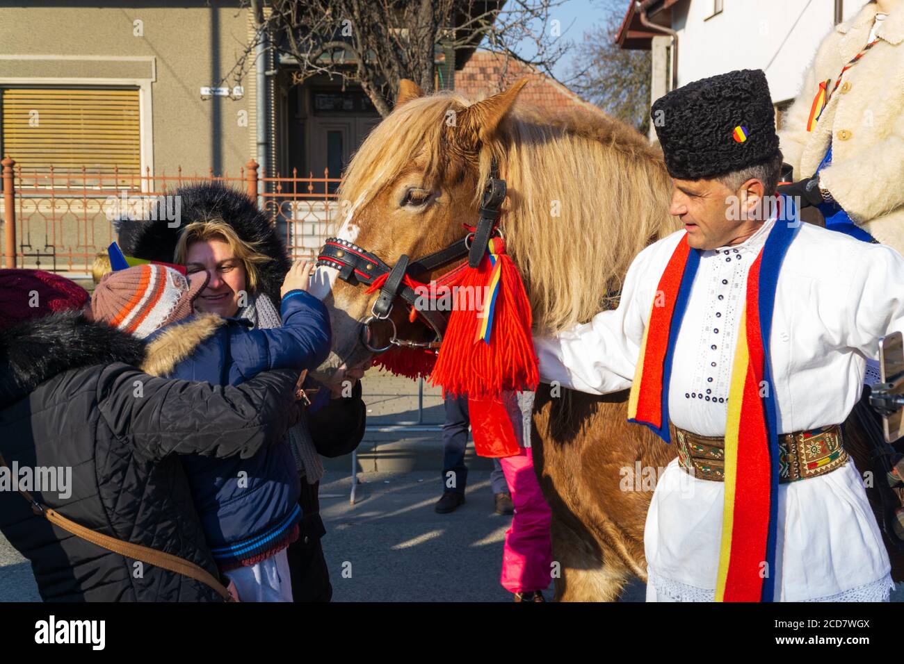 Alba Iulia, Rumänien - 01.12.2018: Menschen streicheln ein Pferd und einen Mann in traditioneller Nationaltracht Stockfoto
