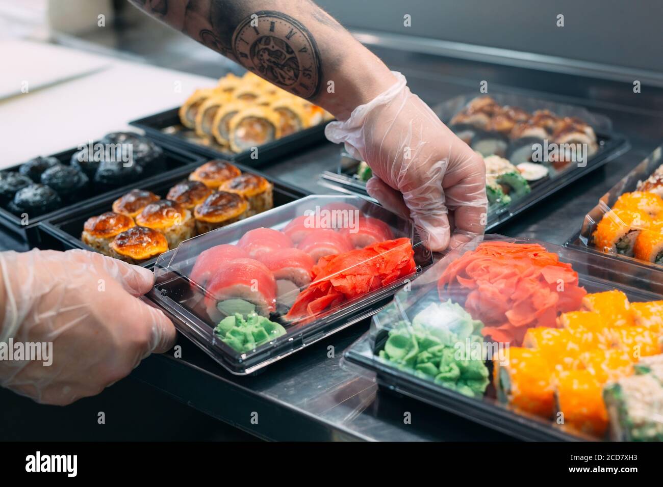 Sushi-Lieferung. Viele Sorten Sushi in einer Plastikbox sind für die Lieferung vorbereitet. Stockfoto