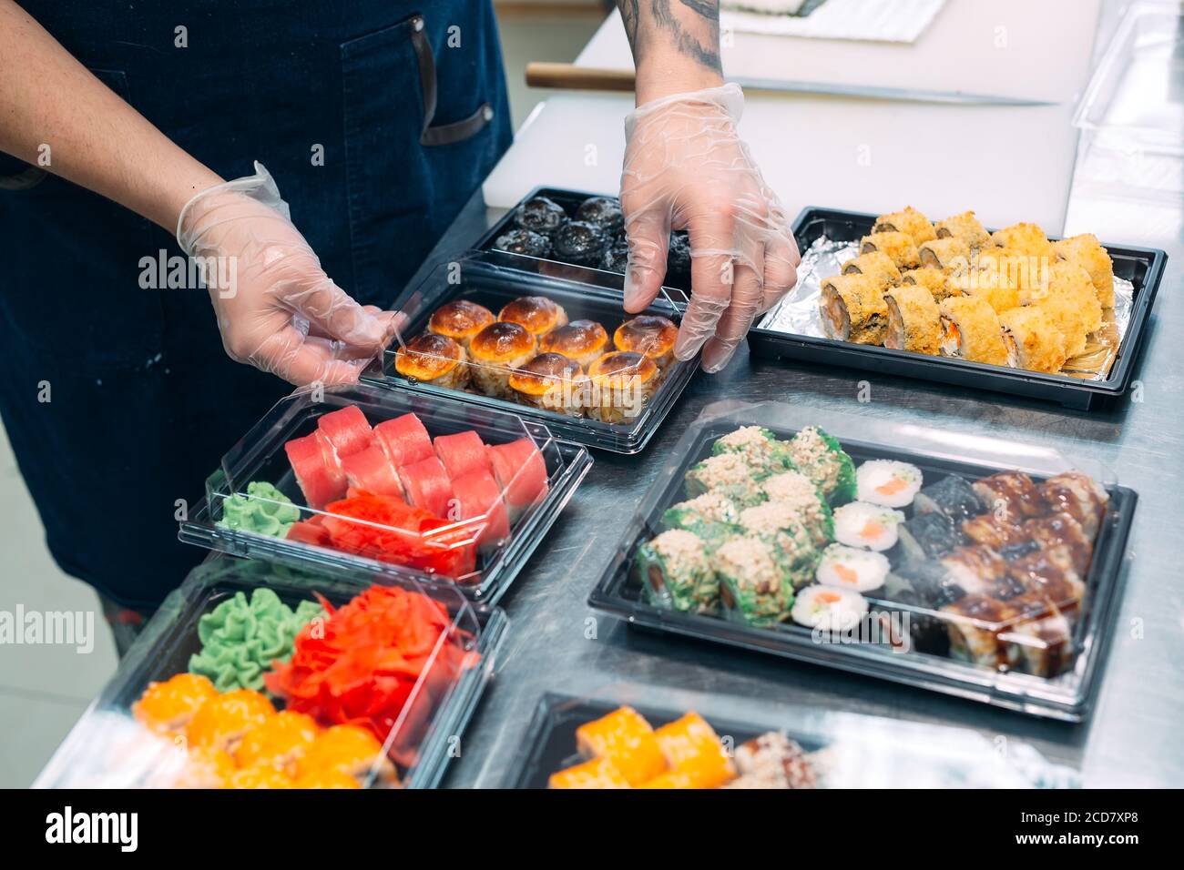 Sushi-Lieferung. Viele Sorten Sushi in einer Plastikbox sind für die Lieferung vorbereitet. Stockfoto
