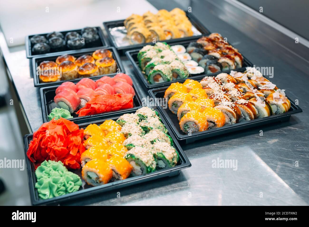 Sushi-Lieferung. Viele Sorten Sushi in einer Plastikbox sind für die Lieferung vorbereitet. Stockfoto