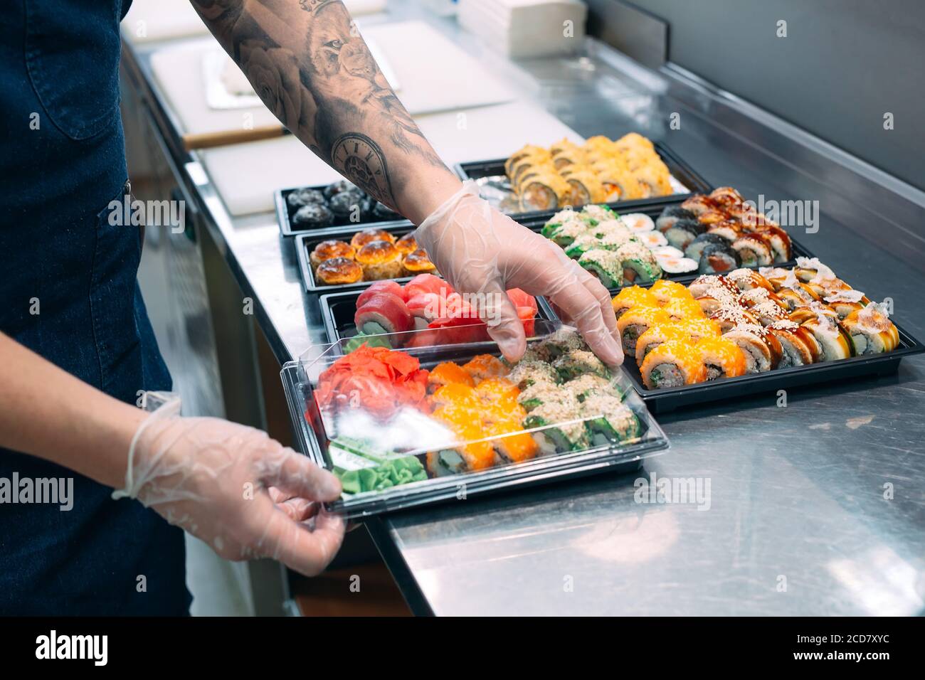 Sushi-Lieferung. Viele Sorten Sushi in einer Plastikbox sind für die Lieferung vorbereitet. Stockfoto